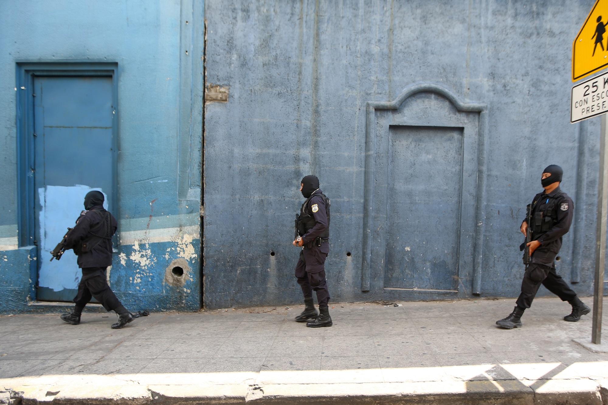 Tres agentes de la PNC patrullan fusil en mano por el Centro Histórico de San Salvador. El personal operativo de la institución alcanzó en 2015 la cifra récord, 23,129 policías, pero desde entonces se acumluan dos años de descensos, consecuencia de la guerra desatada contra las pandillas. Foto Marvin Recinos (AFP).