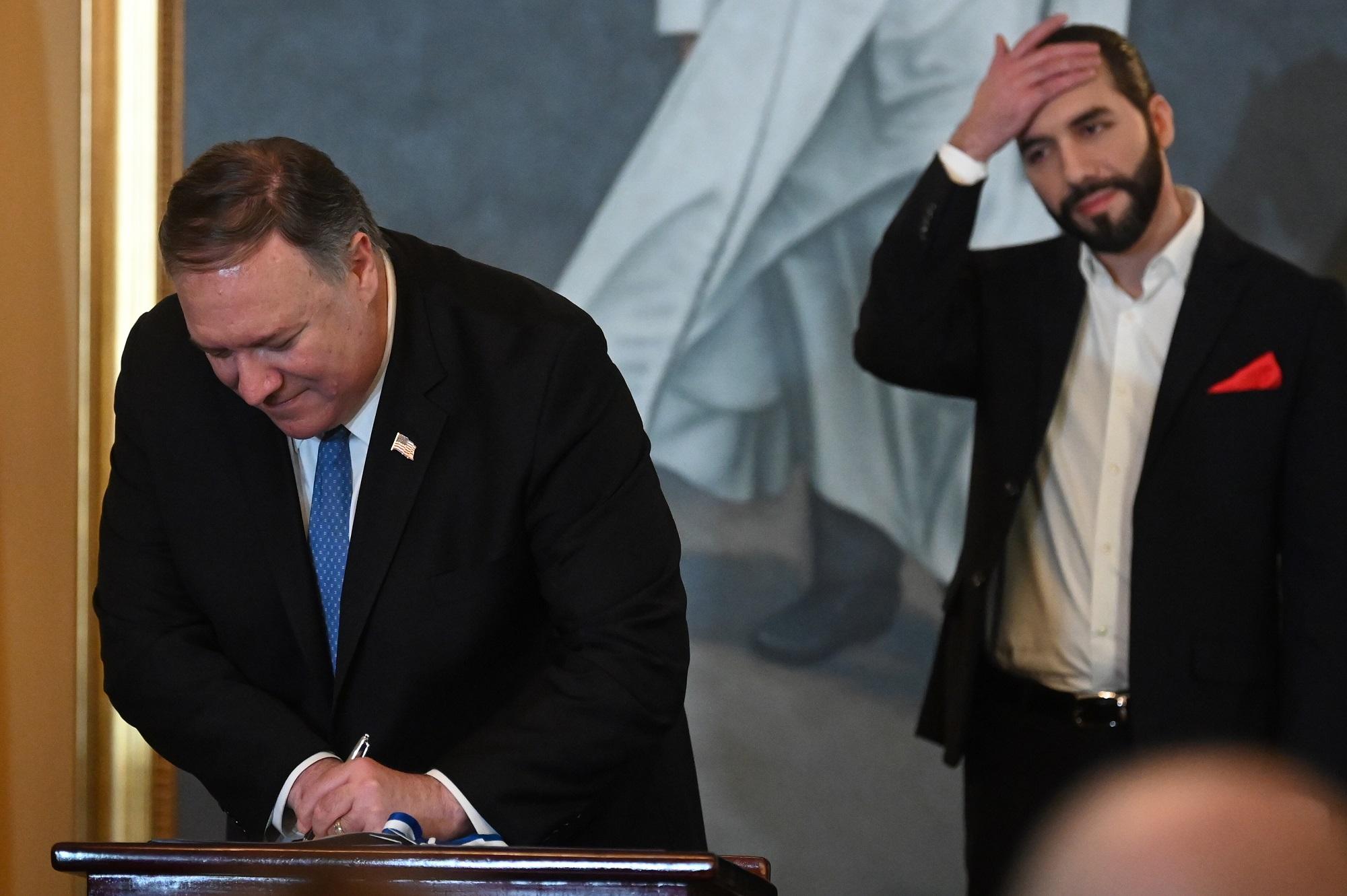 El secretario de Estado de Estados Unidos, Mike Pompeo (izquierda), firma un documento mientras el presidente de El Salvador, Nayib Bukele, hace un gesto, en Casa Presidencial. San Salvador, 21 de julio de 2019. Foto: Marvin Recinos/ AFP.