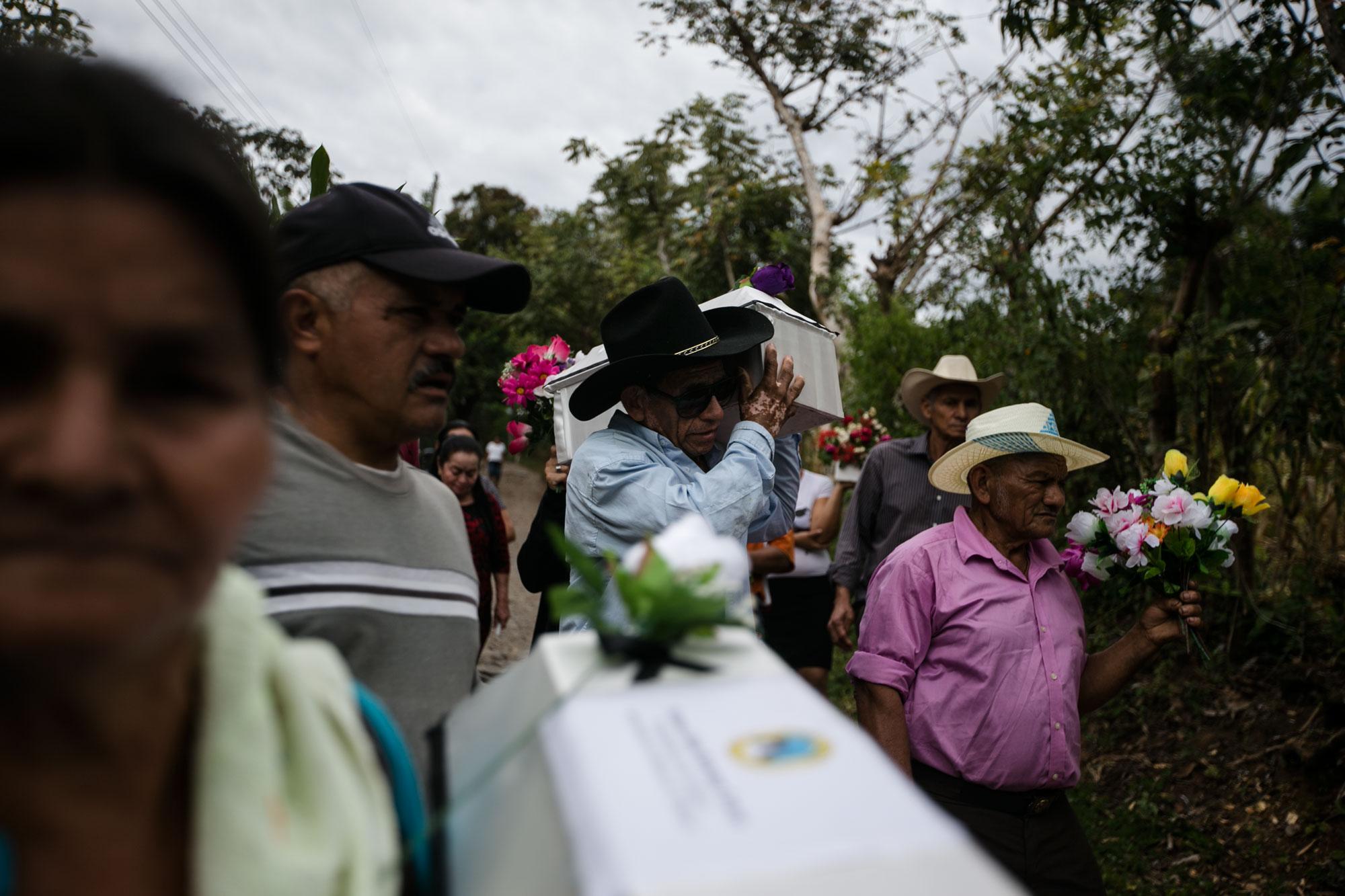 Vecinos de La Joya cargan las cajas con los restos de sus familiares para iniciar con el entierro, el 11 de diciembre de 2016. Las víctimas de La Joya se cuentan entre las de la masacre de El Mozote. Foto: El Faro/ Fred Ramos