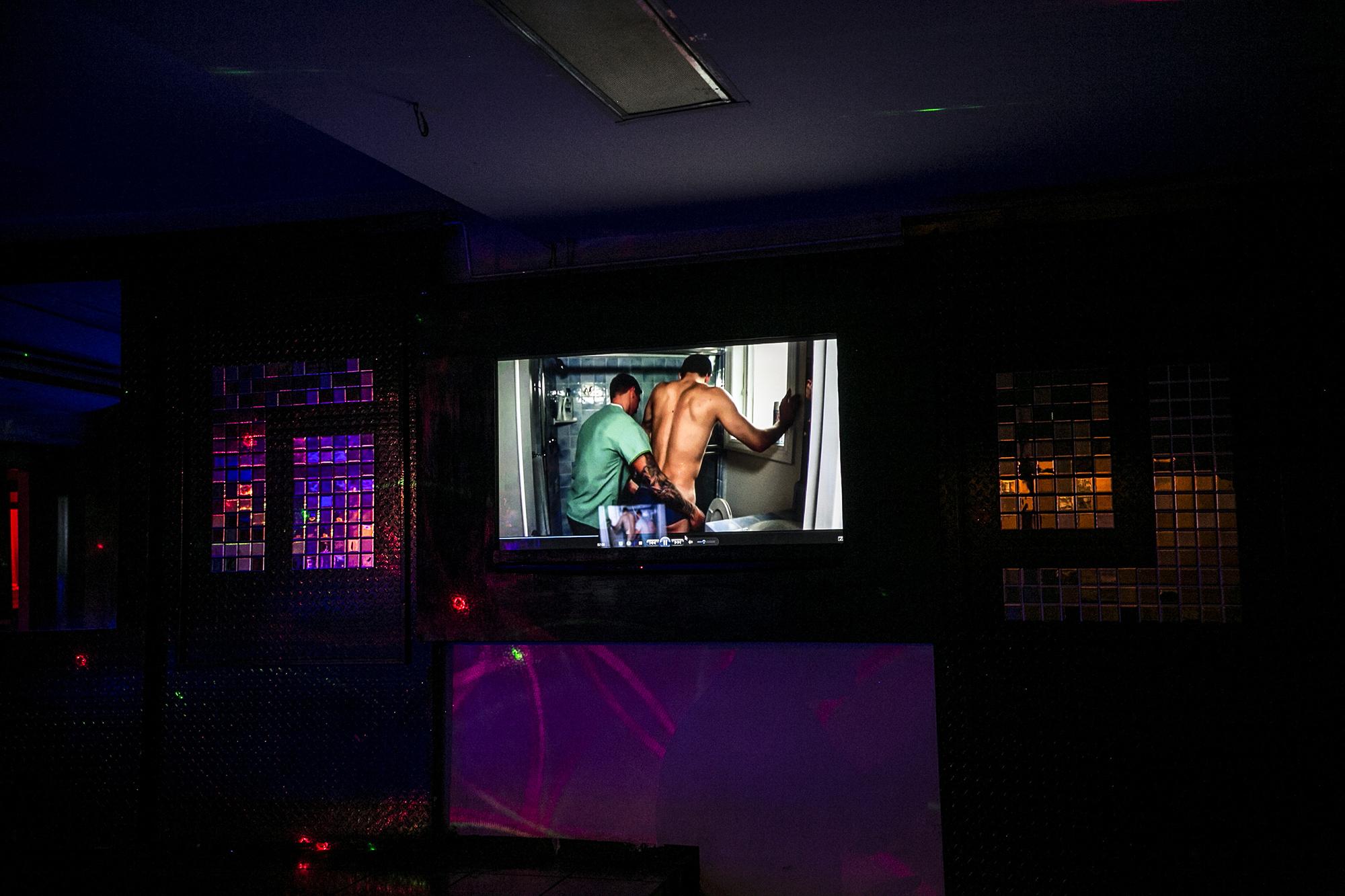 Videos de soft porn  se transmiten simultáneamente mientras la música se encarga de poner a los asistentes a bailar. Son un complemento que pasa más bien desapercibido. Foto de El Faro, por Fred Ramos.
