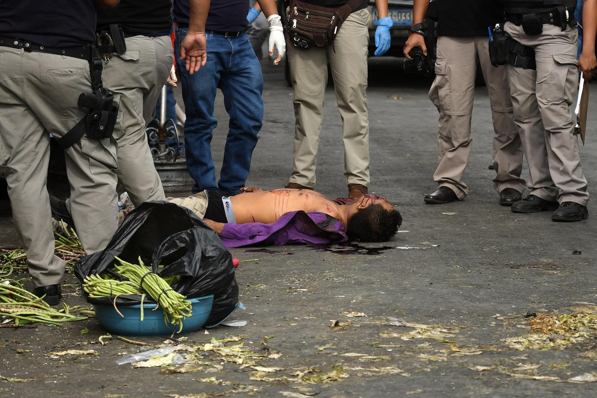 El año 2018 ha arrancado con un alza del 26 % en los asesinatos registrados en El Salvador. En la imagen, autoridades procesan la escena de un homicidio ocurrido en el Centro Histórico de San Salvador. Foto Marvin Recinos (AFP).