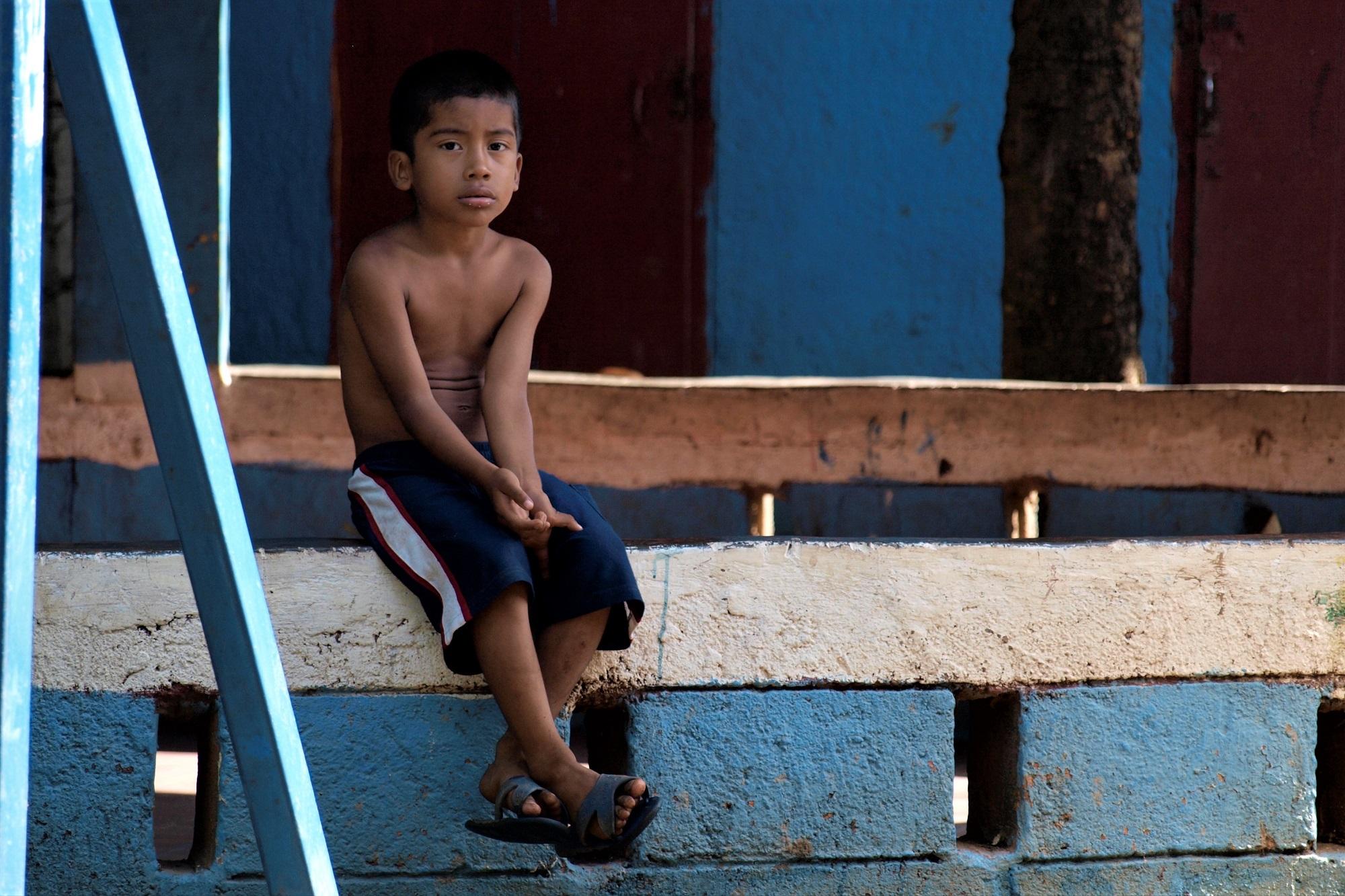 Un niño descansa en un muro de la Olla de la Soya, en el barrio Jorge Dimitrov, en Managua. Foto Roberto Valencia (El Faro).