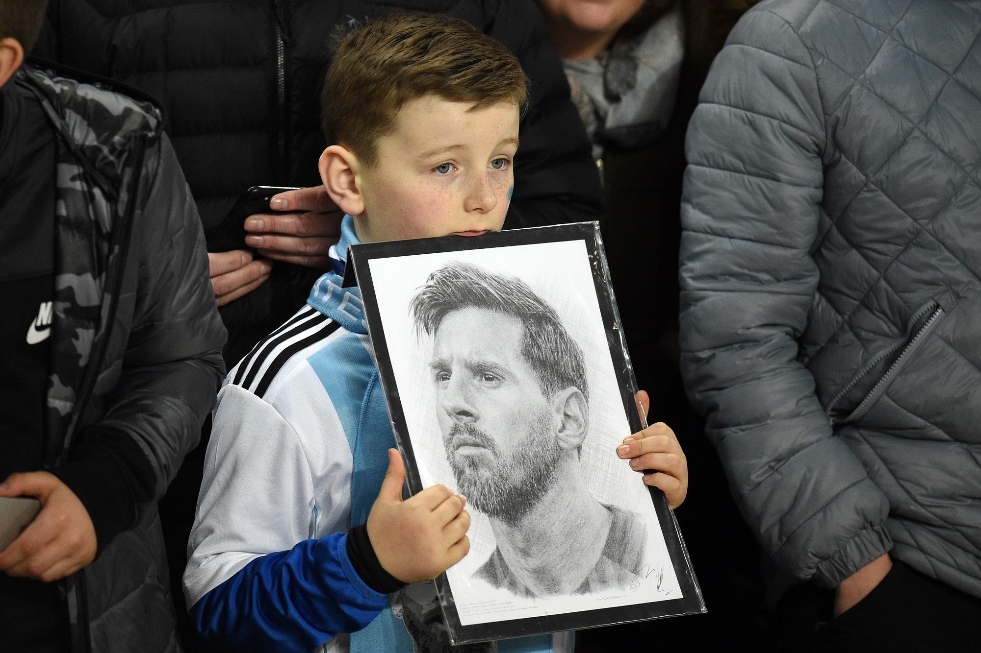 Un niño porta el retrato de Lionel durante el partido amistoso entre Argentina e Italia celebrado el 23 de marzo de 2018. El niño era inglés, de Manchester. Foto Oli Scarff (AFP).