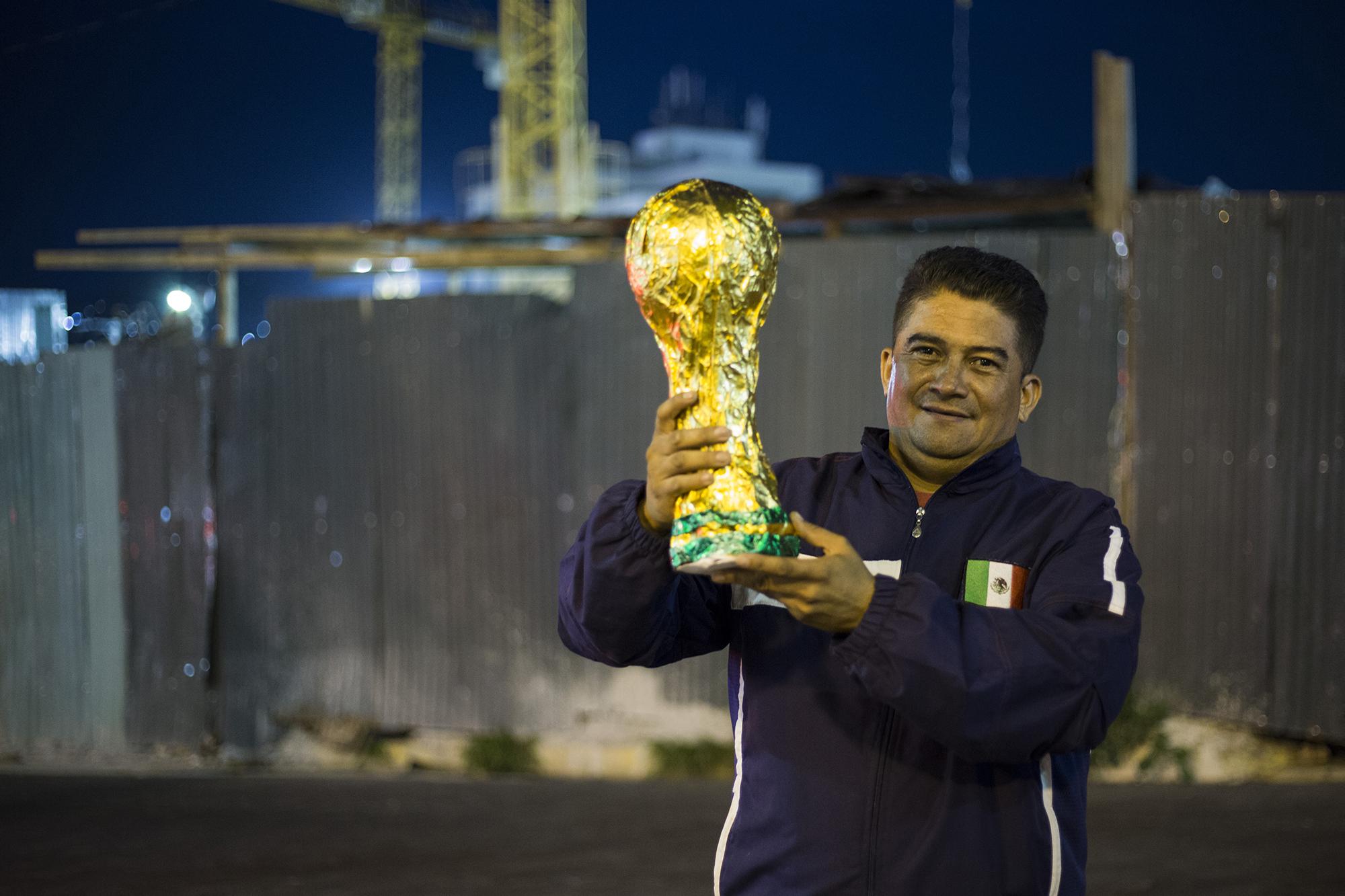Joel Zamora muestra el trofeo de la Copa del Mundo que ha creado, con el que realizó una travesía para llegar hasta Rusia, sede del torneo de la FIFA. Foto Víctor Peña (El Faro).