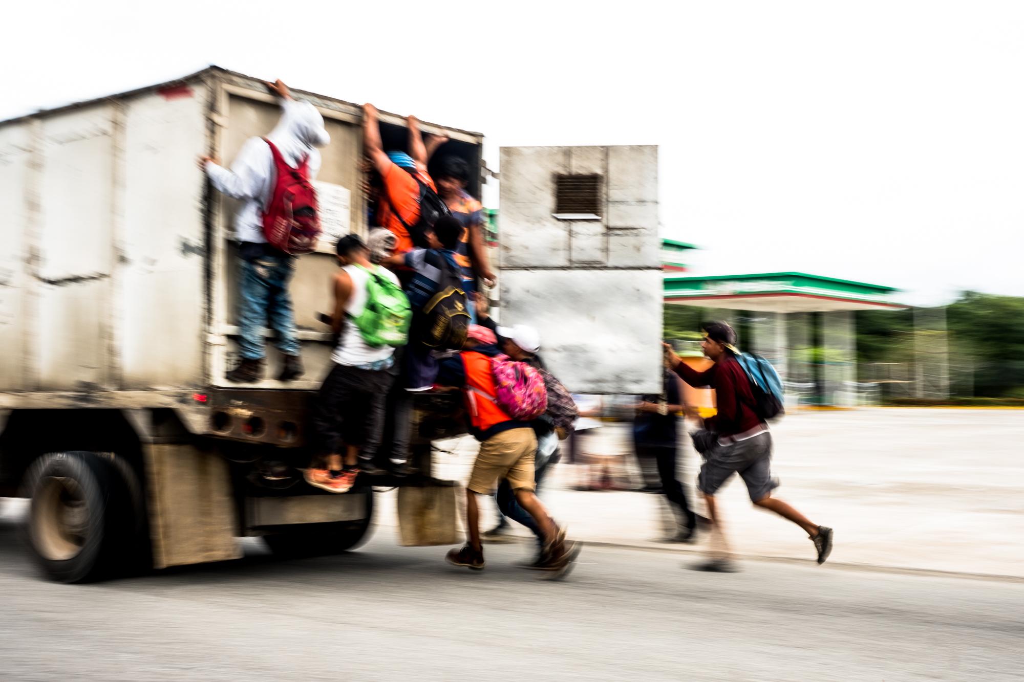 Migrantes centroamericanos corren tras un camión para abordarlo en su trayecto hacia Puebla, el 3 de noviembre. Foto: Fred Ramos