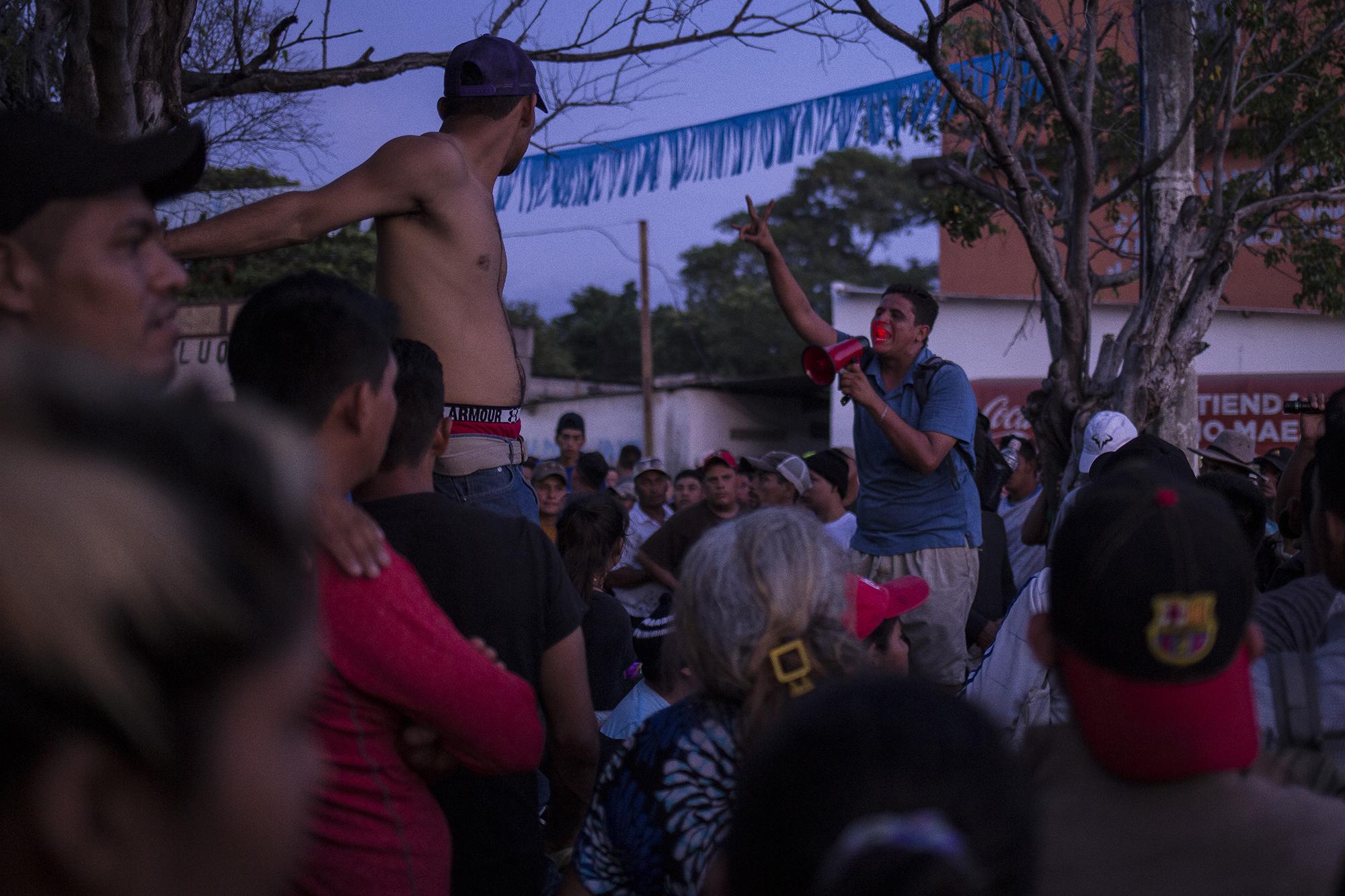 Marvin, el vendedor de dulces, habla con el grupo de migrantes, en la ciudad de Pedro de Alvarado, un pueblo fronterizo entre El Salvador y Guatemala, antes de que lograran cruzar a México a principios de noviembre. Foto: Víctor Peña.