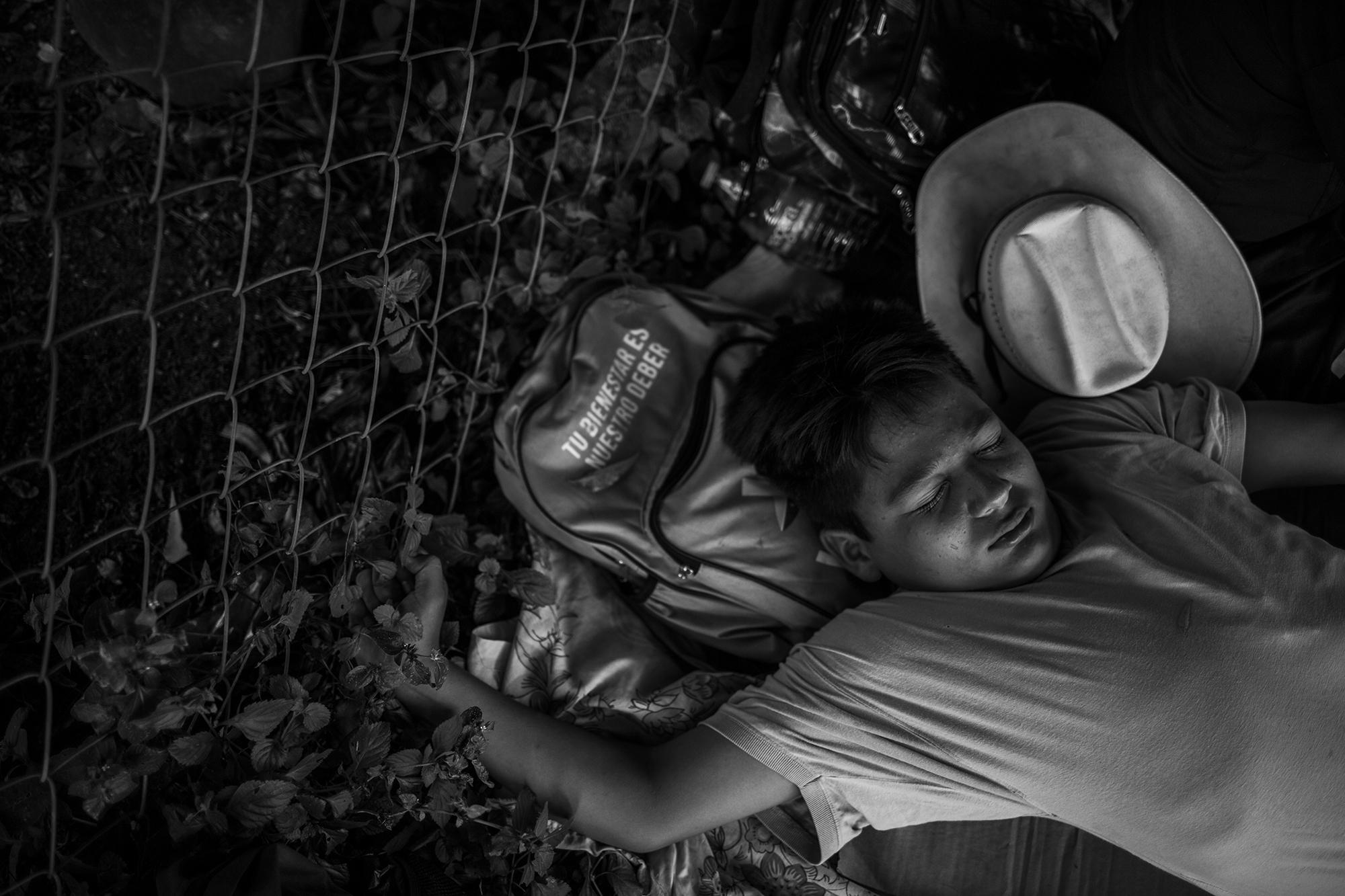 Dani descansa sobre el monte, a la orilla de la carretera, cerca de la estación migratoria del municipio de Huehuetán, durante una pausa de la caravana. Dani tiene en mente buscar asilo en México. Así como en El Salvador, no hay nadie que lo espere en Estados Unidos.