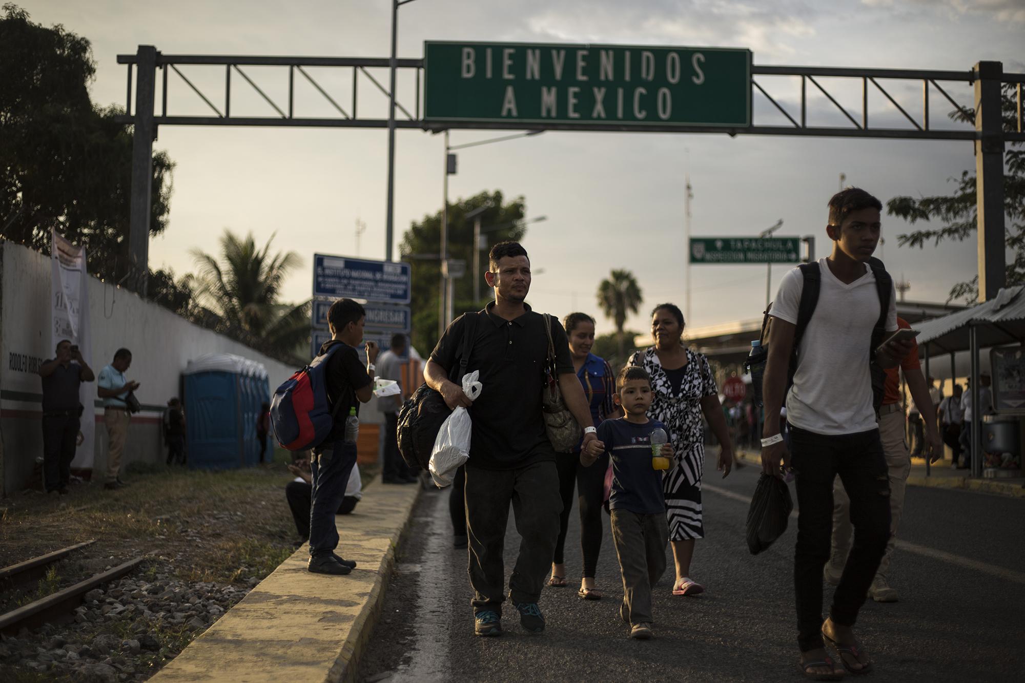 Una familia camina justo después de haberse registrado en la aduana de Ciudad Hidalgo, en México. El Gobierno de México ha pedido a los migrantes que se someten a este proceso cinco días de espera para obtener una visa humanitaria. Foto: Víctor Peña.