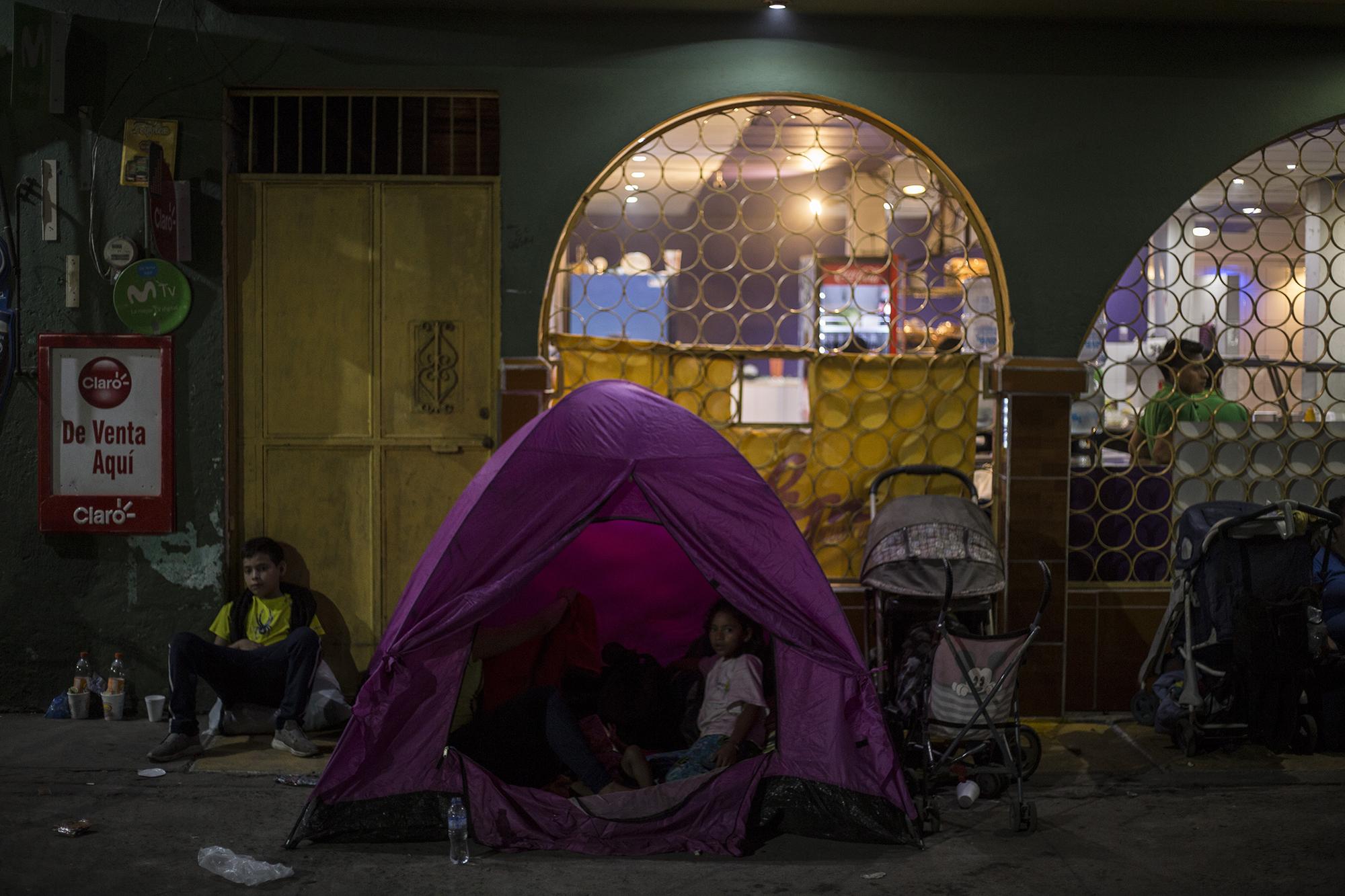 El parque de la ciudad de Ayutla, en la frontera Tecún Umán, Guatemala, luce desde hace meses como un campamento permanente de migrantes que pretenden ingresar a México. Una familia descansa la noche del viernes 18 de enero en esa plaza.