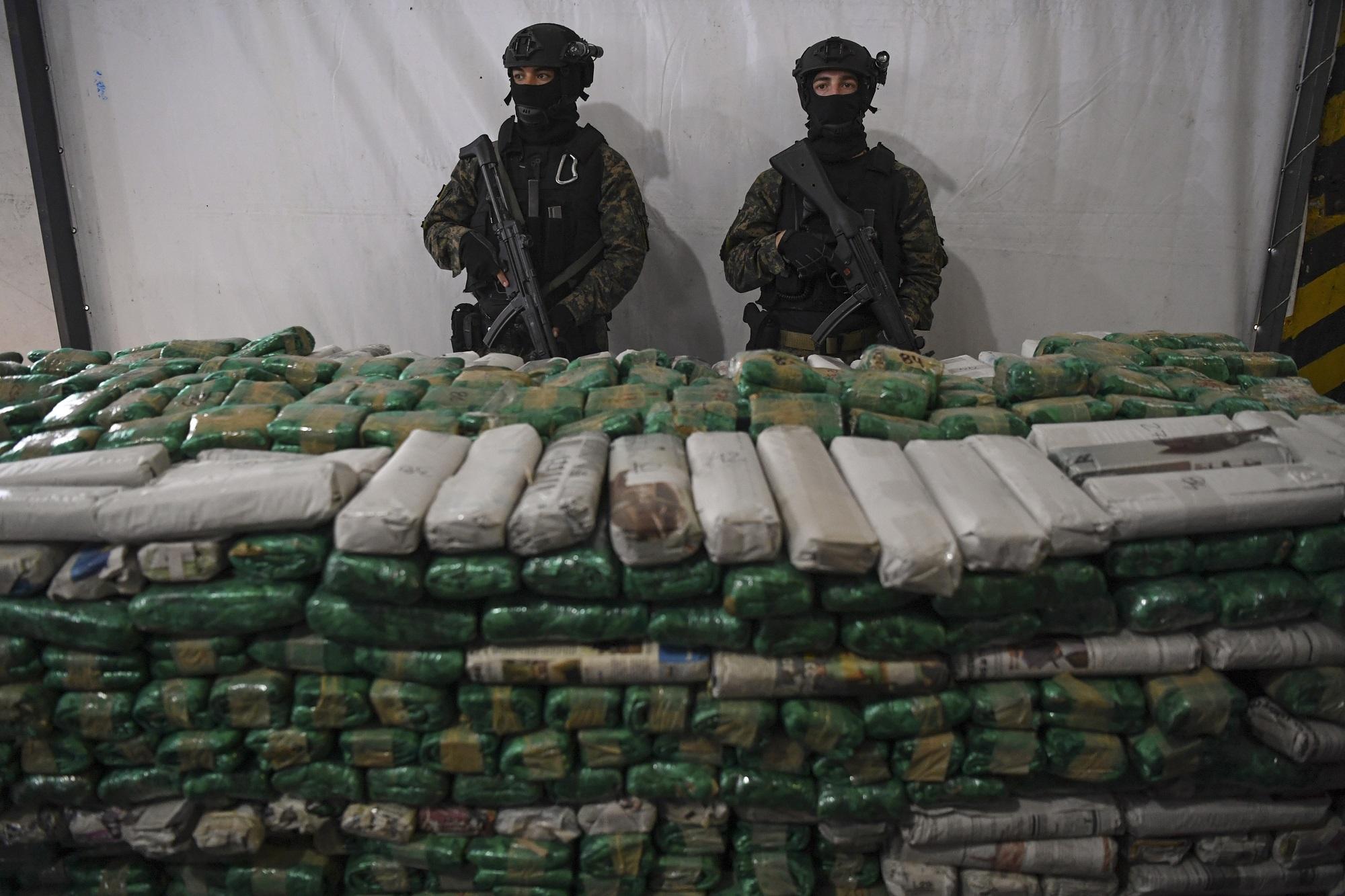 Dos agentes de la Gendarmería Nacional posan detrás de un importante alijo de cocaína incautado en Argentina. Foto Eitan Abramovich (AFP).