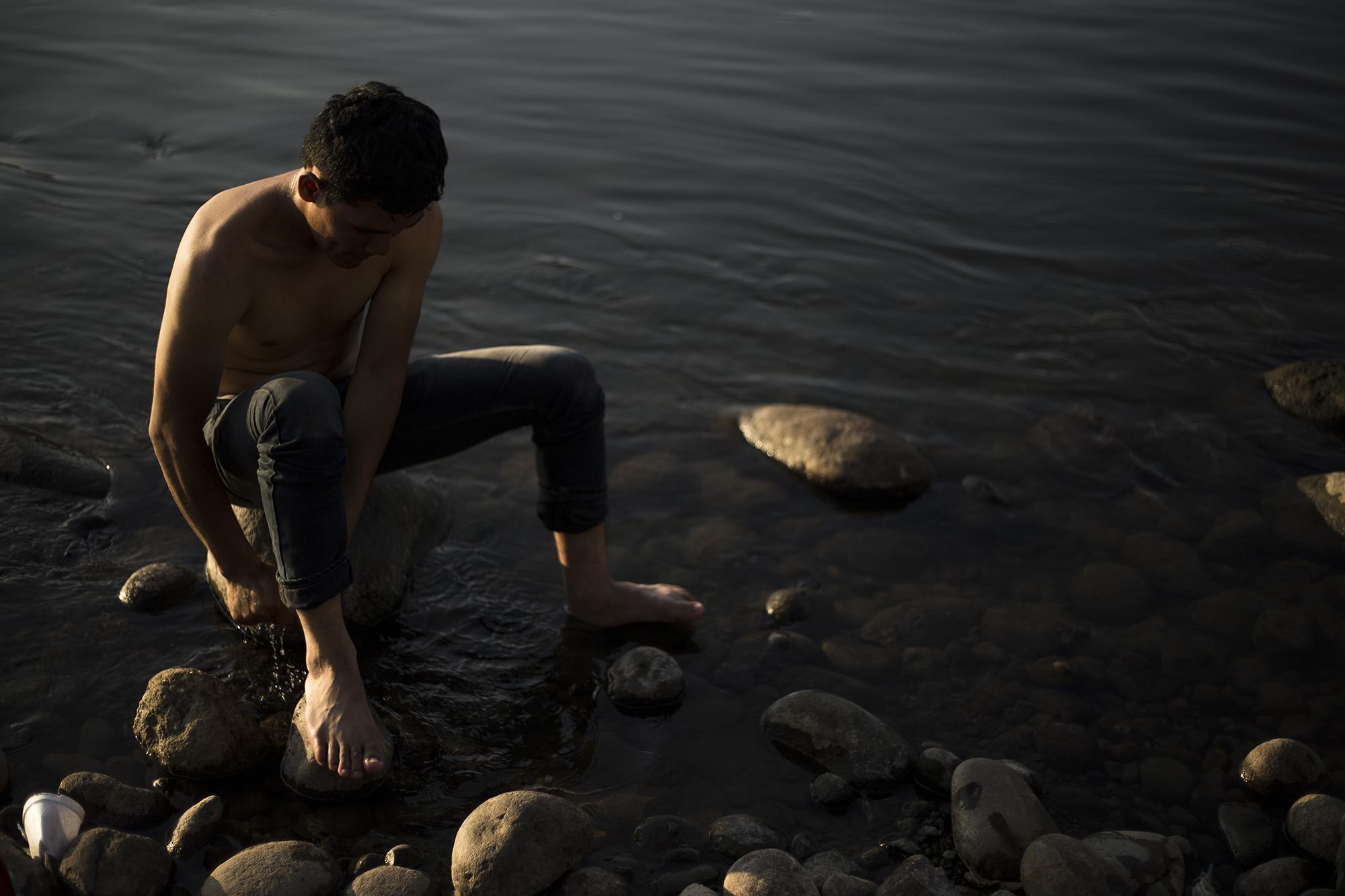 Un migrante guatemalteco toma un baño en el río Suchiate, el 18 de enero de 2019. Él espera a que su trámite sea aprobado por las autoridades mexicanas y se le extienda su credencial para ingresar a México. Foto: Víctor Peña.