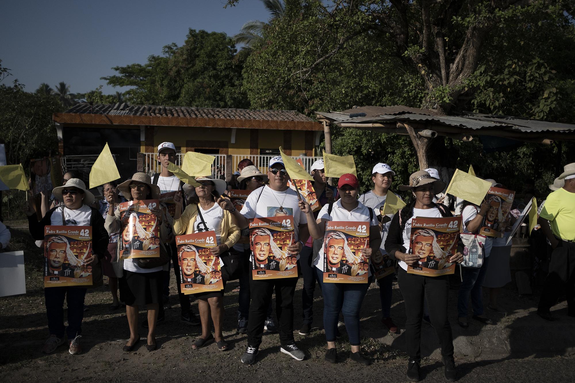 Un grupo de feligreses de la Arquidiócesis de San Salvador hacen un pasillo durante el recorrido de cuatro kilómetros de la caravana en conmemoración al 42 aniversario martirial del padre Rutilio Grande. 