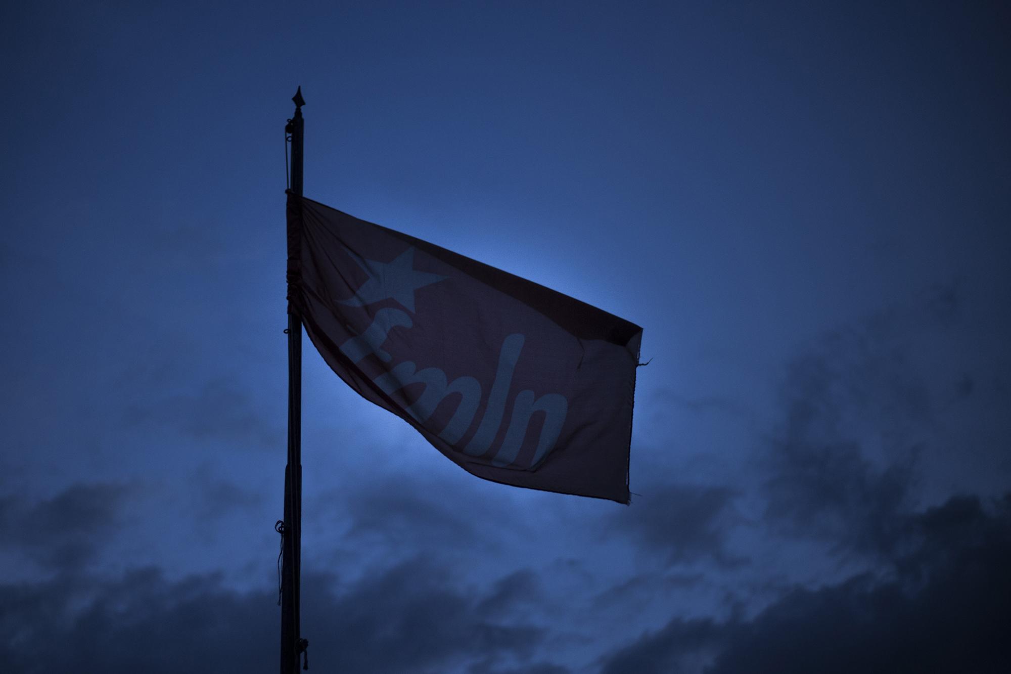 La bandera rota del FMLN ondea sobre las instalaciones de la sede central del partido, en la colonia Buenos Aires de San Salvador. Foto: Víctor Peña.