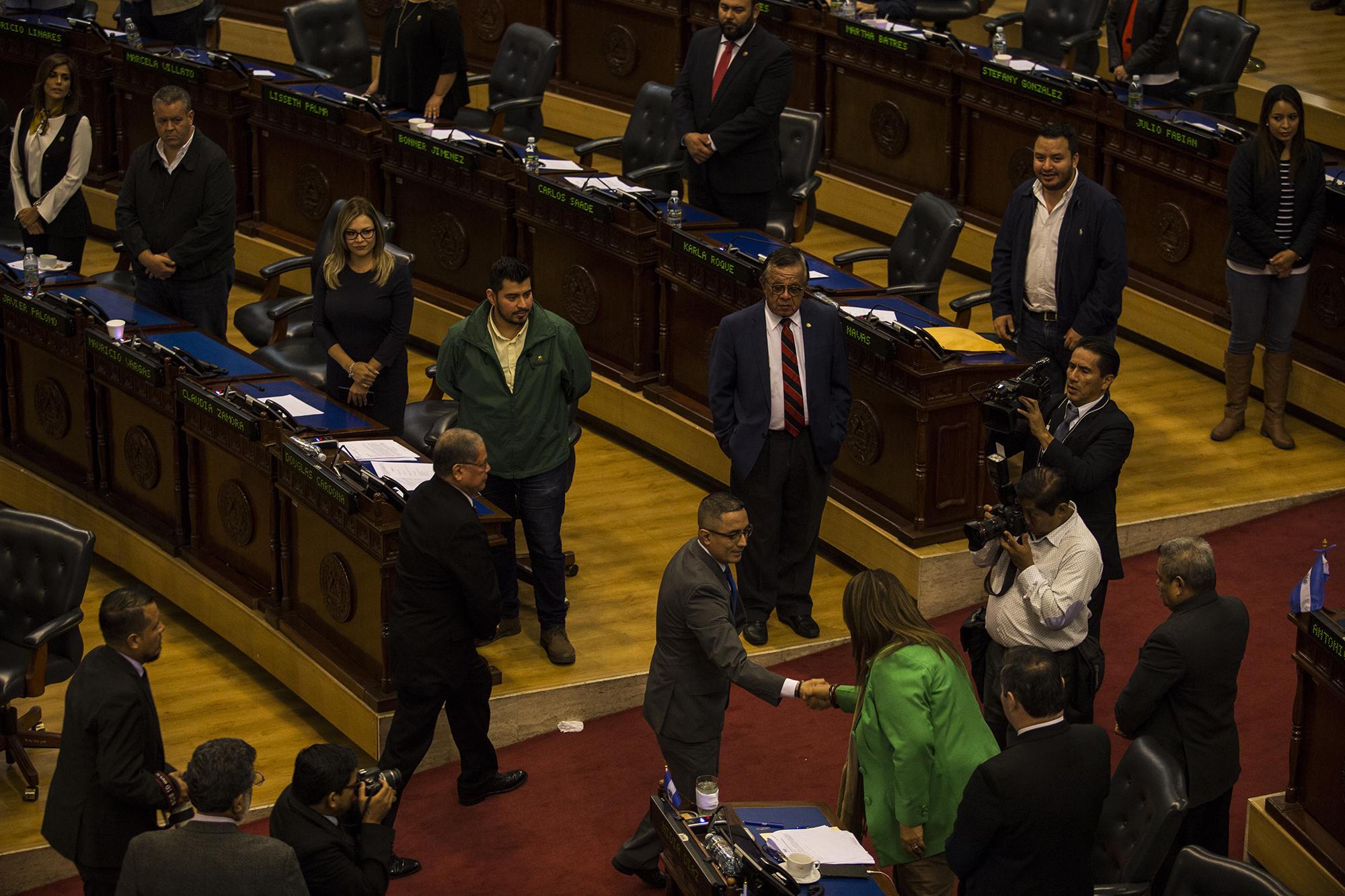 José Apolonio Tobar, nuevo procurador de Derechos Humanos, saluda a Nidia Díaz, del FMLN. A su espalda, en la bancada de Arena lo observan dos diputados propietarios y algunos de los suplentes que respaldaron la elección. Foto: Víctor Peña.