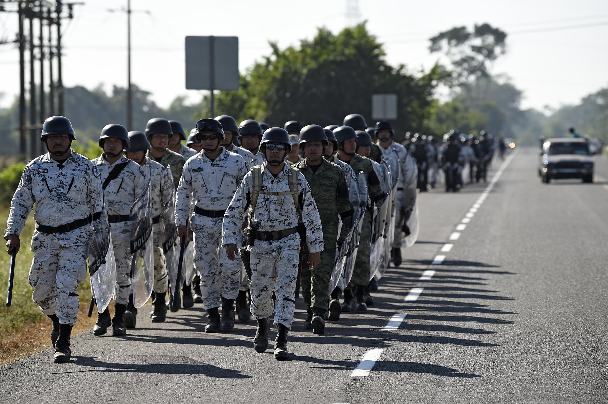 Cientos de agentes de la Policía Militar caminaron por una carretera desde Ciudad Hidalgo hasta Tapachula, Estado de Chiapas, México, para detener a la caravana. Foto de AFP: Alfredo Estrella.