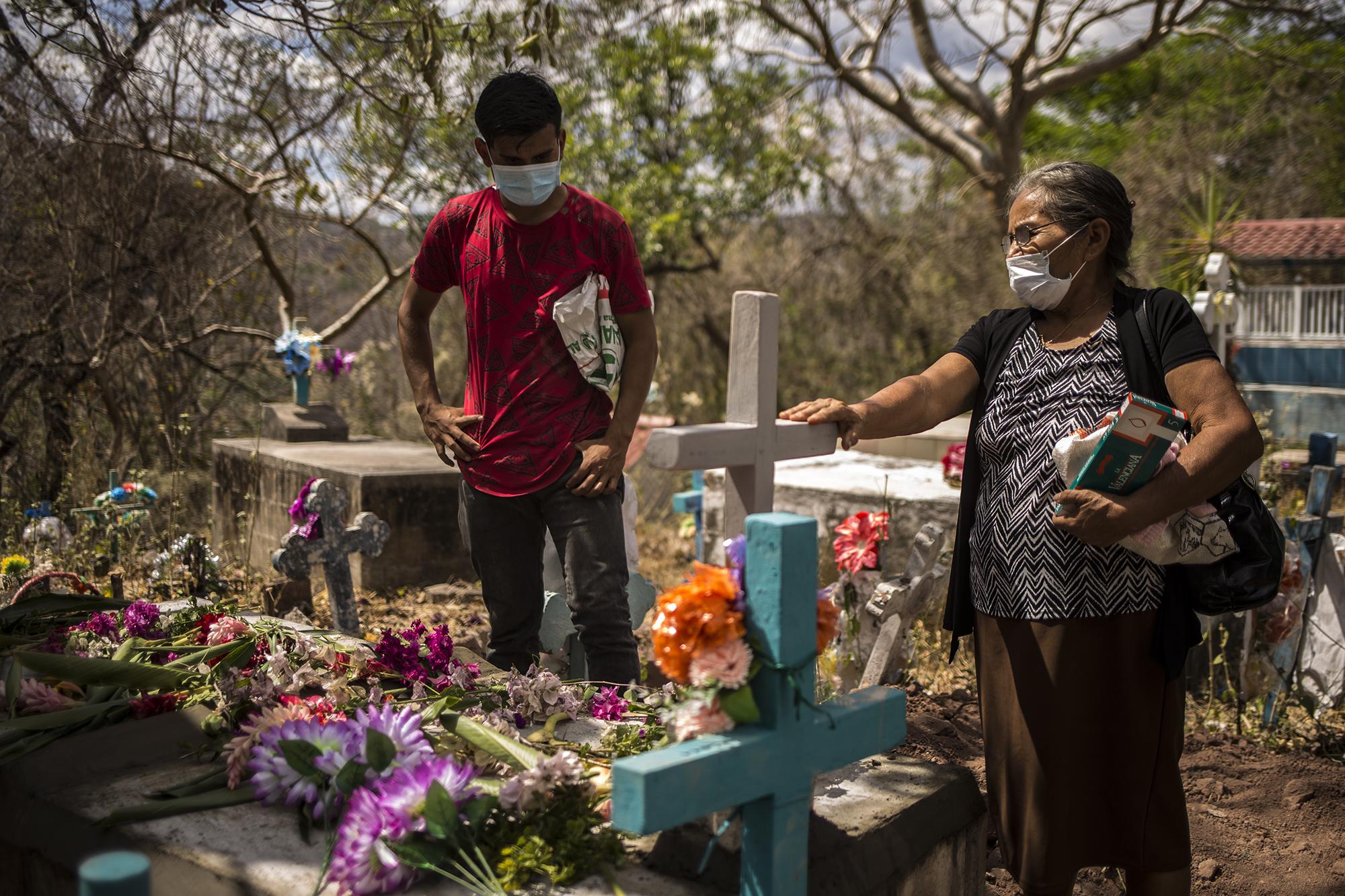 Rosario López says goodbye to her husband, Ángel Mejía. “He’s in his last house now,” she said. Municipal Cemetery of Meanguera, Morazán. Photo for El Faro: Víctor Peña.