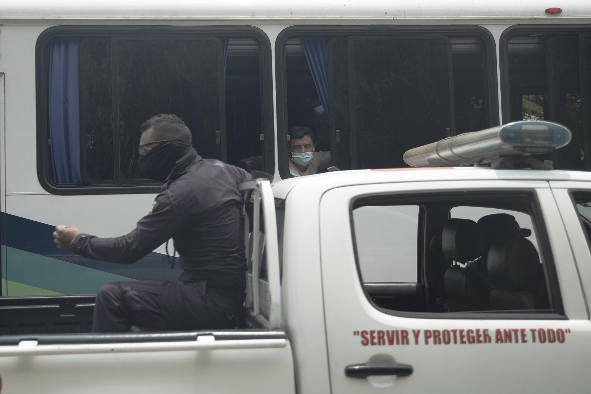 As the police transferred the new arrivals from the airport to a quarantine facility, agents tried to prevent El Faro from photographing the bus carrying the deportees. At the highway exit toward San Jacinto, a police checkpoint momentarily detained a team of reporters from El Faro, preventing them from learning to which facility the group would be taken. Photo: Carlos Barrera/El Faro