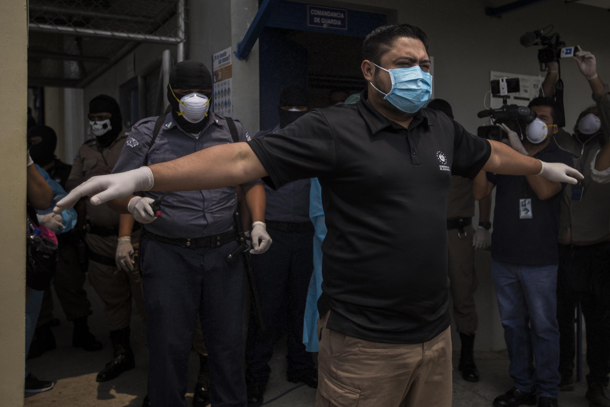 A prison guard disinfects the director of prisons, Osiris Luna, before he enters Level 3 of the Maximum Security Prison in Izalco, in the Department of Sonsonante. Luna held a press conference on April 27 to announce new measures to be taken inside the prisons after an increase in murders the previous weekend. Photo from El Faro: Víctor Peña.