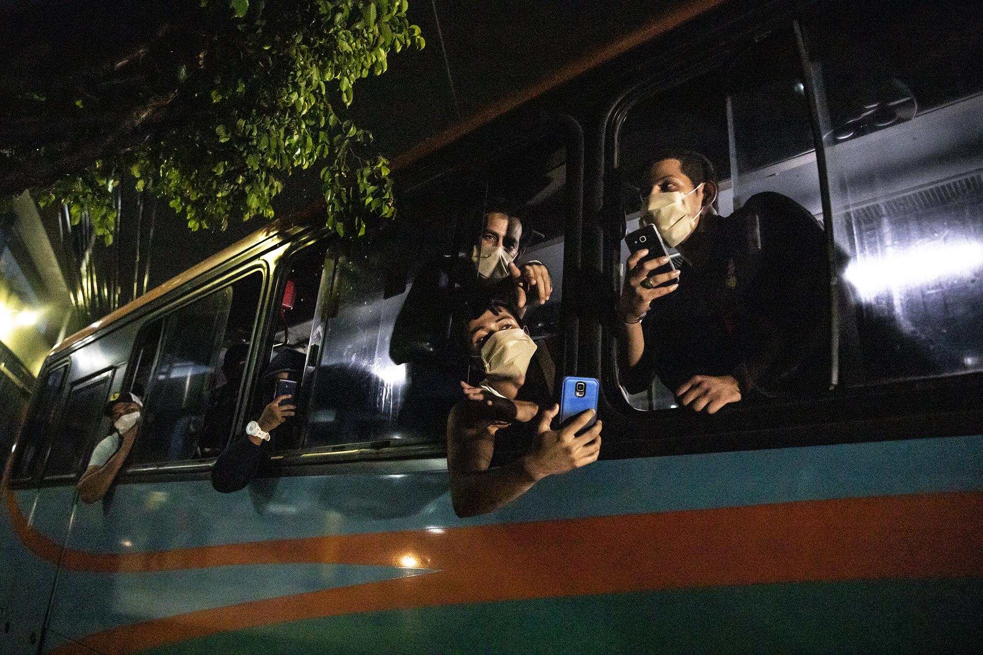 Un autobús con personas detenidas por supuestamente violar la cuarentena sale desde el edificio Gamaliel, en la capital, hacia San Miguel, a donde un grupo fue trasladado. No les dieron explicación alguna. Foto de El Faro: Carlos Barrera.