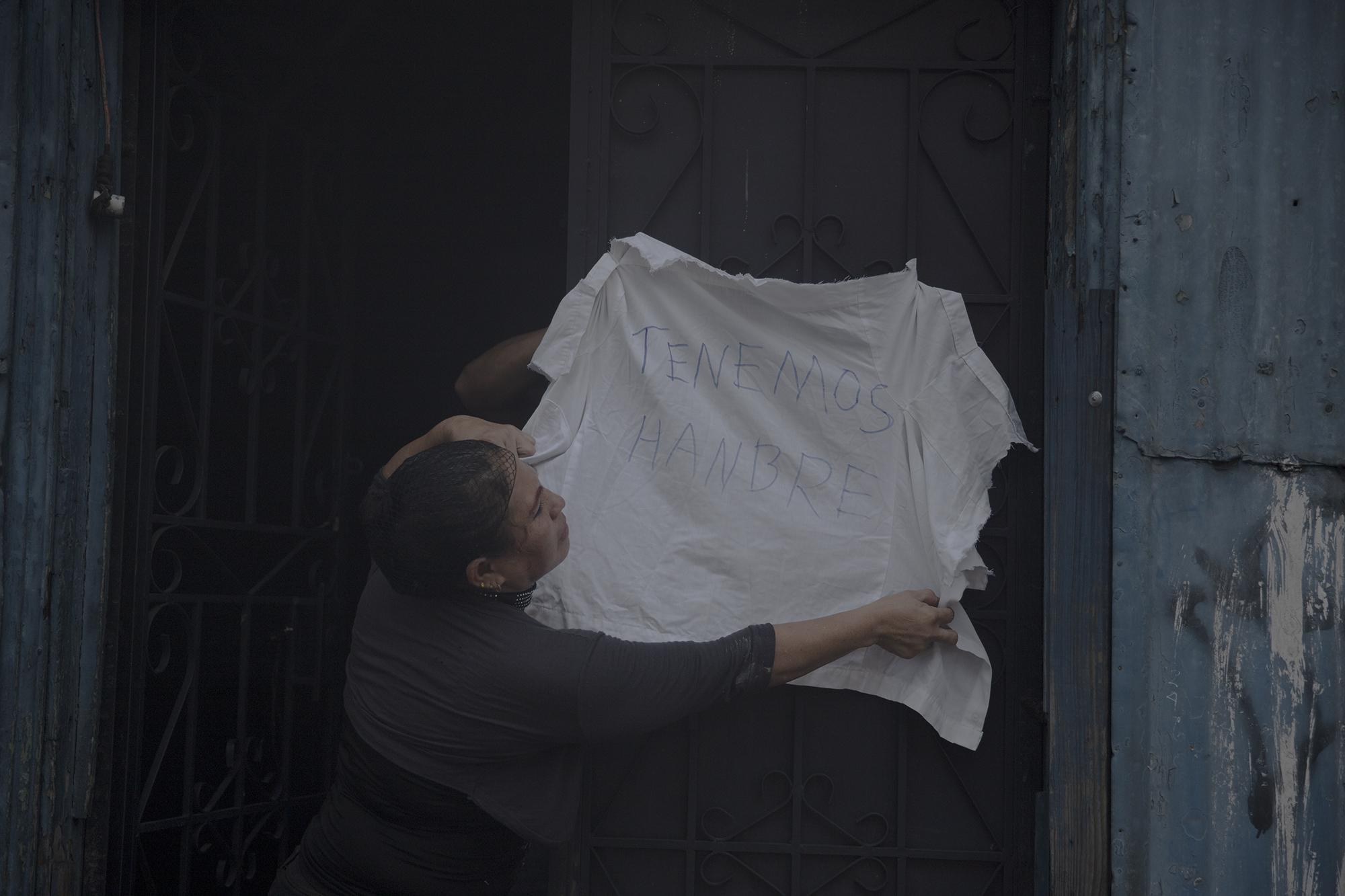 Blanca Lidia López cuelga un trapo blanco en la puerta con una inscripción que dice, 