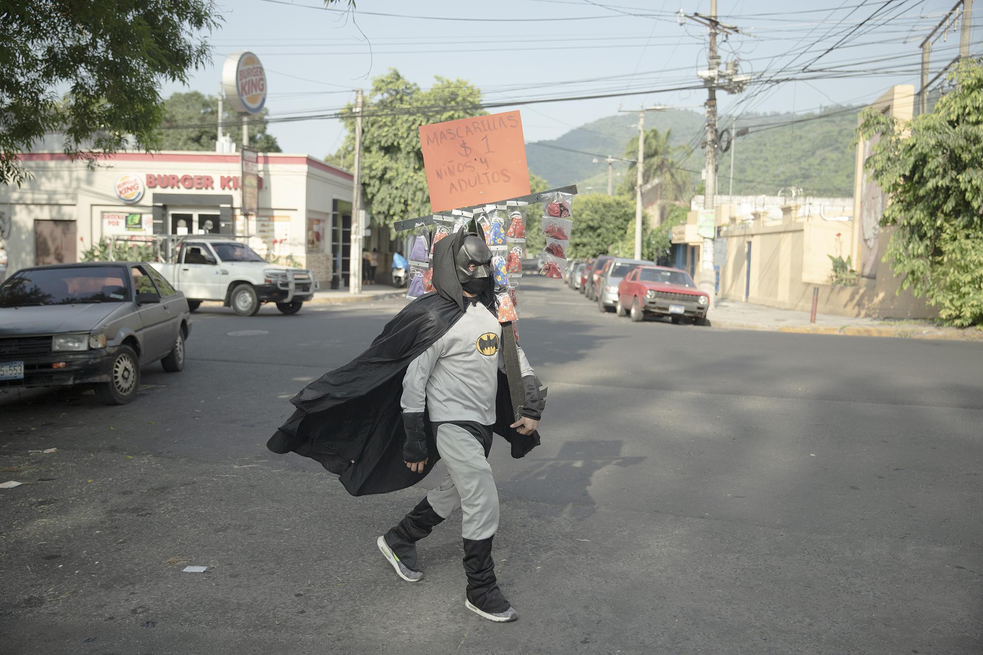 Durante casi toda la cuarentena Batman se ha movilizado en los alrededores de la Plaza San Jacinto para vender las mascarillas que elabora en su casa. Foto de El Faro: Carlos Barrera