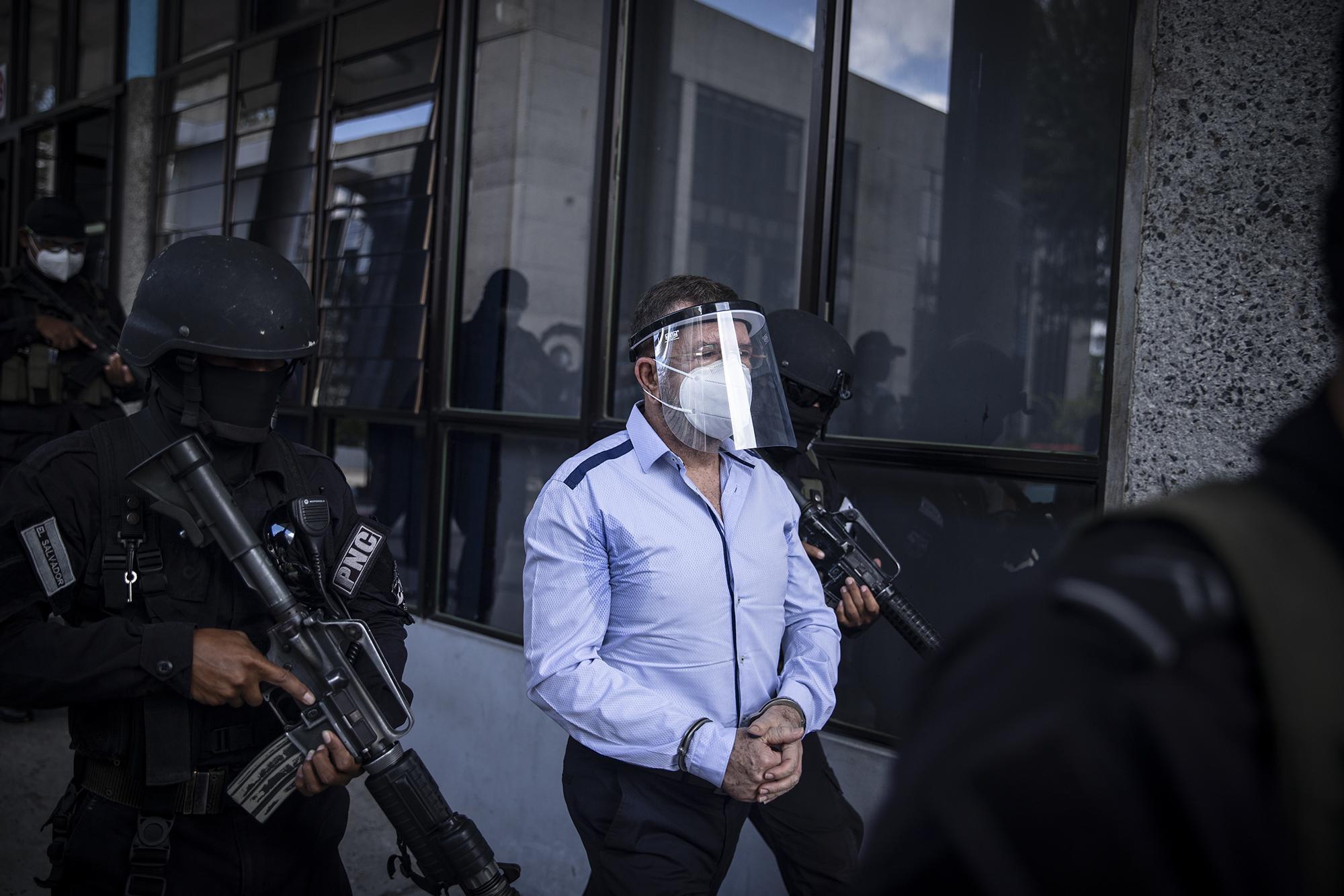 Former Minister of Defense and Security, David Munguía Payés, being escorted by police officers after an initial hearing at the Isidro Menéndez Court in San Salvador. Photo from El Faro: Carlos Barrera