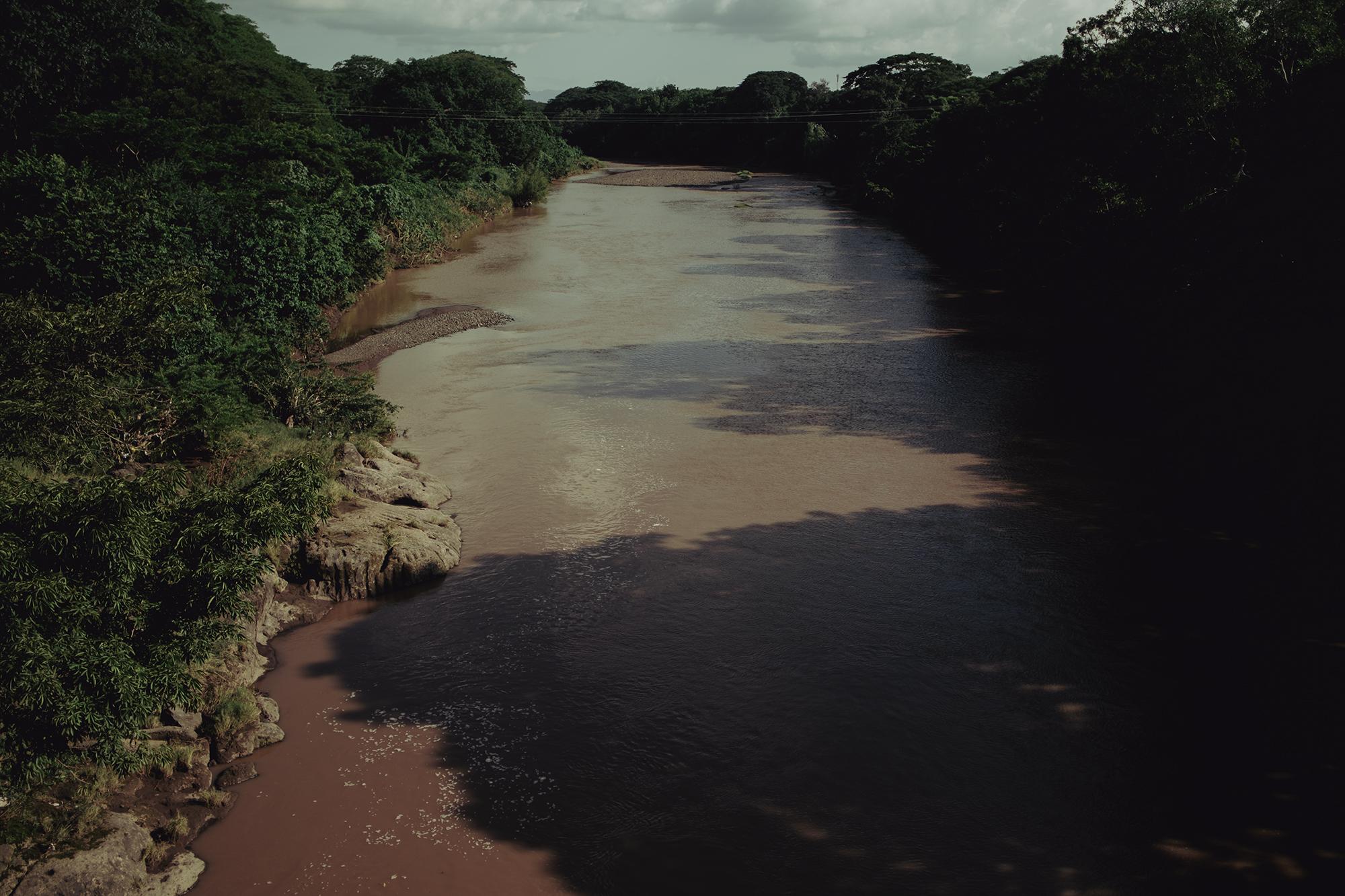 The banks of the Río Grande span four departments in eastern El Salvador: Morazán, San Miguel, La Unión, and Usulután. The community of Urbina 2, San Miguel, is located along the right-side bank pictured above. Each successive river swell threatens to level the community. The families have fled to elevated ground on the opposite side. 