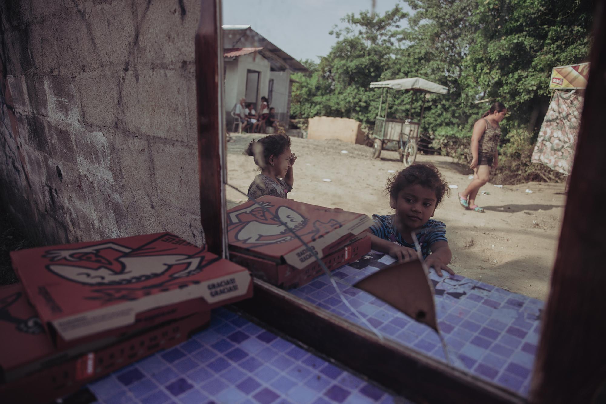 Larisa Hernández juega en lo que quedó de un mueble que fue arrastrado de una casa en la comunidad Canaán en el municipio de La Lima durante la tormenta Eta. La mayoría de familias de ese sector se ha refugiado en la carretera que va de San Pedro Sula a Progreso.