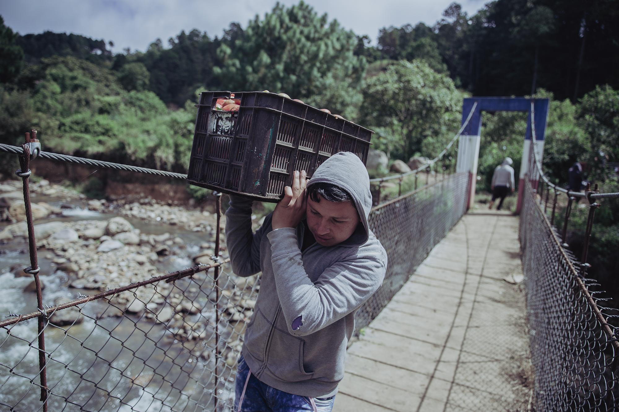Rafael Gutiérrez crosses the bridge over the Sumpul River in Las Pilas, Chalatenango. This border crossing between the two countries has no restrictions for local farm workers . Photo by Carlos Barrera / El Faro.