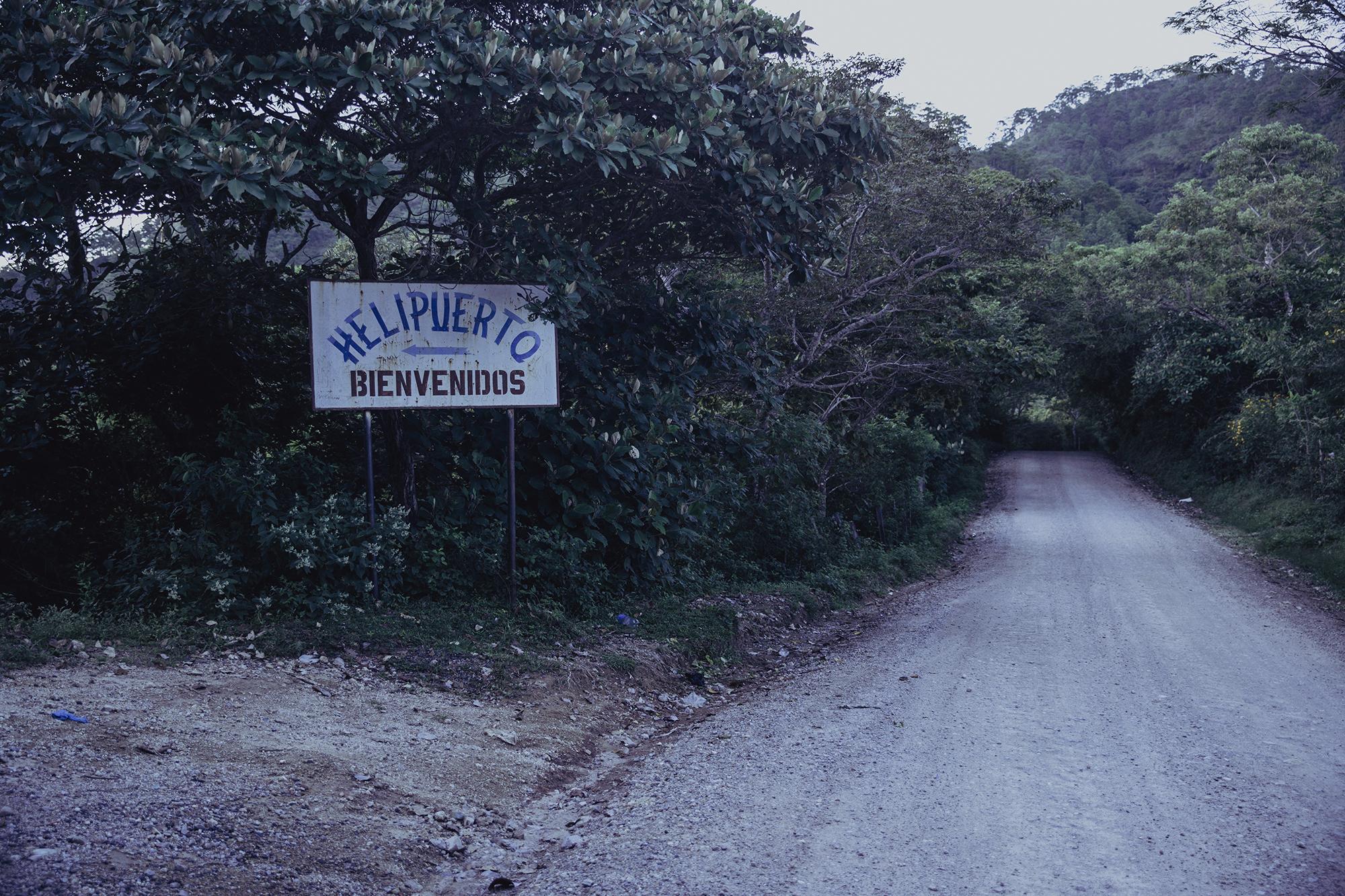A sign points to the entrance to a heliport, six kilometers from the municipality of Dulce Nombre de María, down the tough stretch of road to San Fernando. Photo by El Faro: Carlos Barrera.