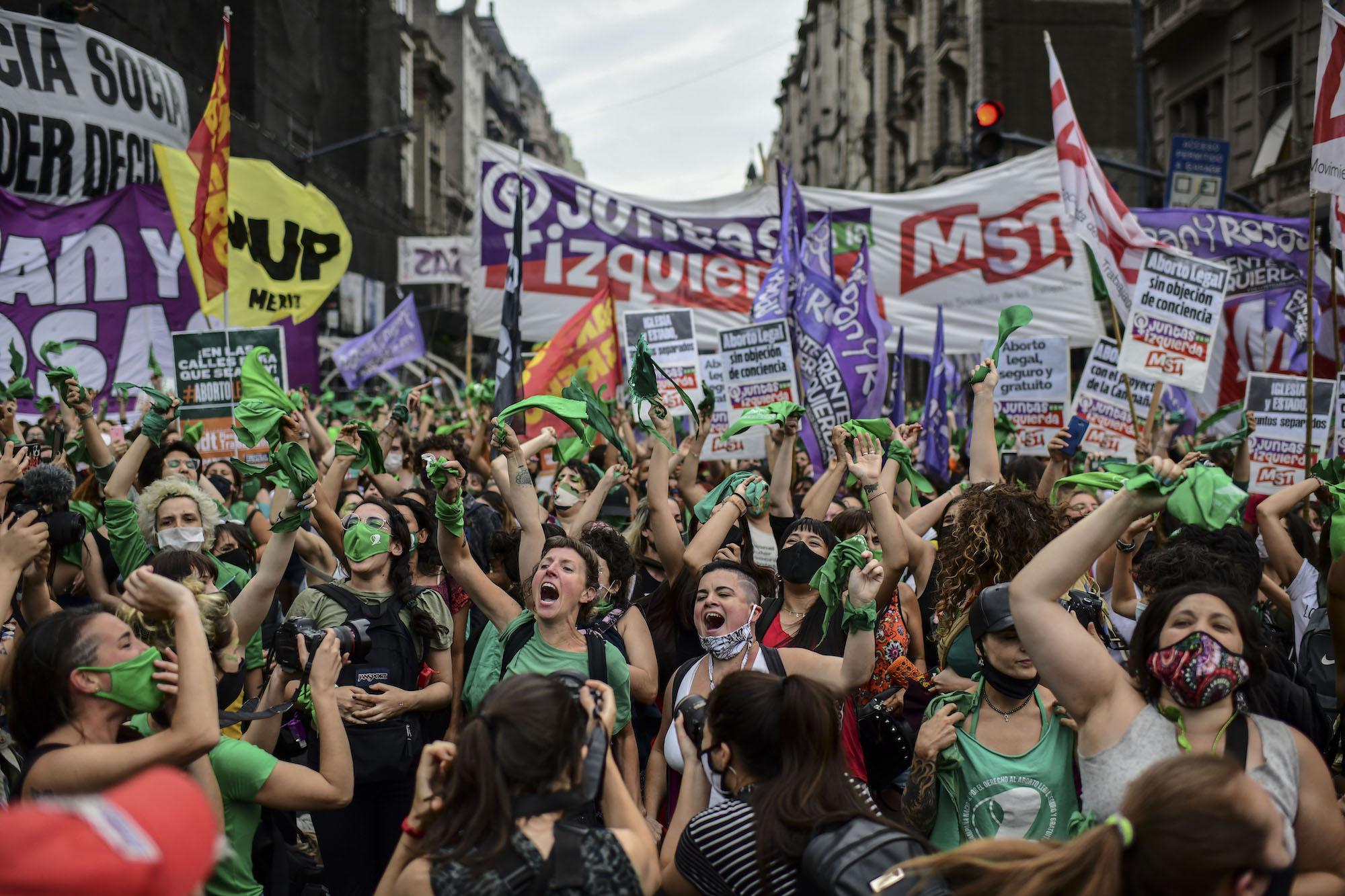 Mujeres celebran afuera del congreso argentino tras la aprobación de la ley para legalizar el aborto. Foto por Ronaldo Schemidt / AFP.