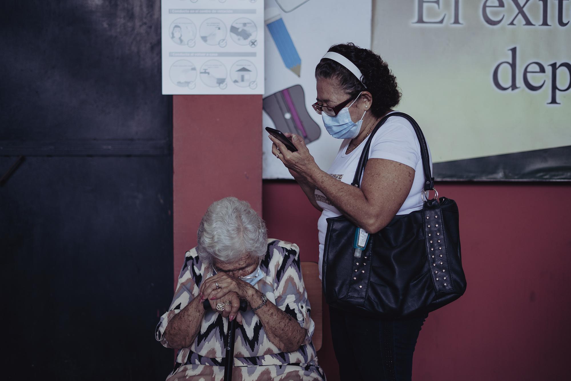 Amanda Lozano, de 91 años, llegó a votar al centro escolar República de Brasil, en San Jacinto. Un error del personal que sirve en mesa hizo que Amanda votara en la JRV equivocada. La anciana lloró al saber que su voto sería anulado, pero un delegado del TSE levantó un acta y el voto se aprobó. Según la hija de Amanda, Guadalupe González, ella padece estrés debido al cáncer terminal que padece. Foto de El Faro: Carlos Barrera