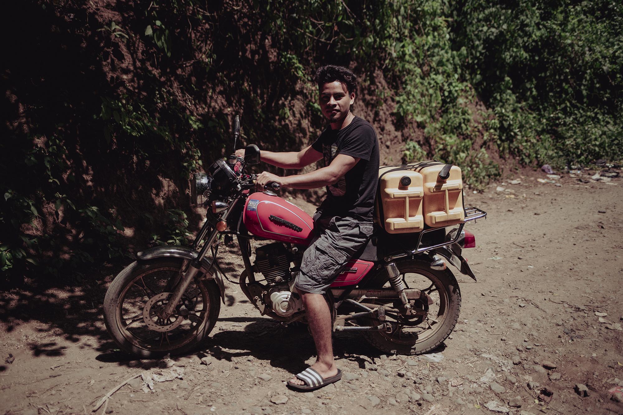 Melvin Alvarenga viaja cada dos días en su motocicleta hasta un nacimiento de agua ubicado en el cantón Las Delicias, Berlín. La familia Alvarenga utiliza el agua del nacimiento exclusivamente para tomar. Foto de El Faro: Carlos Barrera