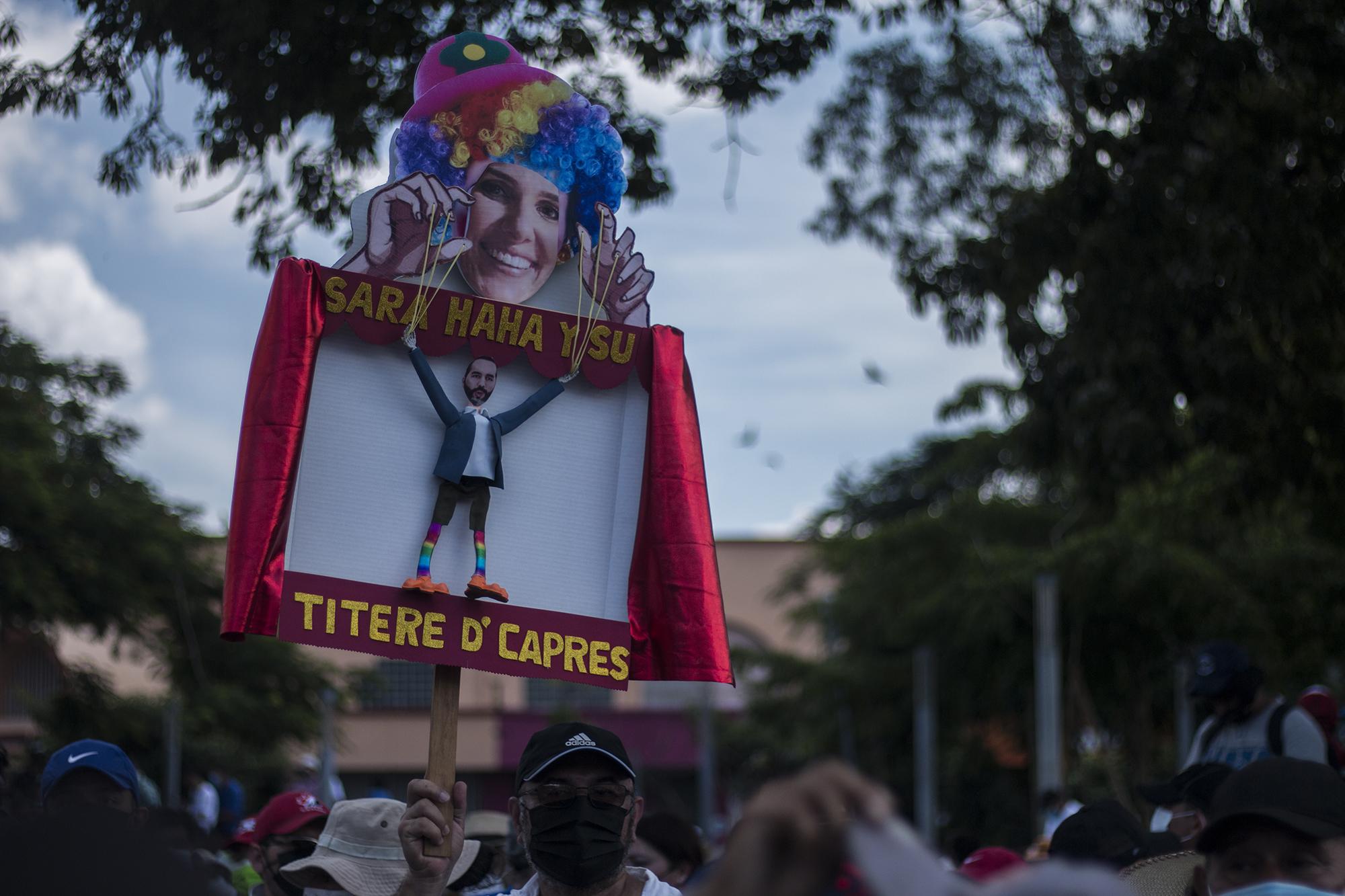 Sara Hanna, la asesora venezolana del presidente Nayib Bukele, fue también centro de críticas durante la manifestación. Un cartel hacía parodia sobre sus funciones en el Gobierno de El Salvador. 
