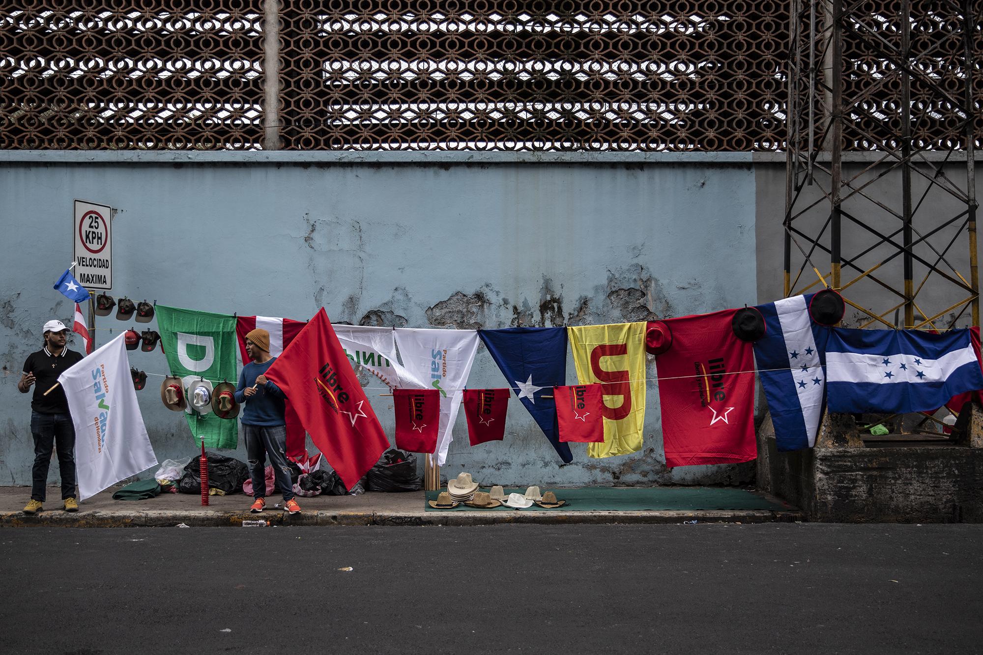 Kevin Suazo y Cristian Corea venden banderas de los partidos en contienda en las elecciones generales de Honduras. 