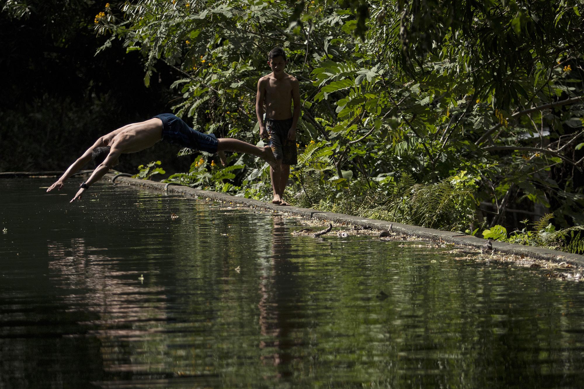 Habitantes de la Hacienda La Labor disfrutan de las aguas termales del estanque que abastece a más de diez comunidades que le rodean. Foto de El Faro: Víctor Peña. 