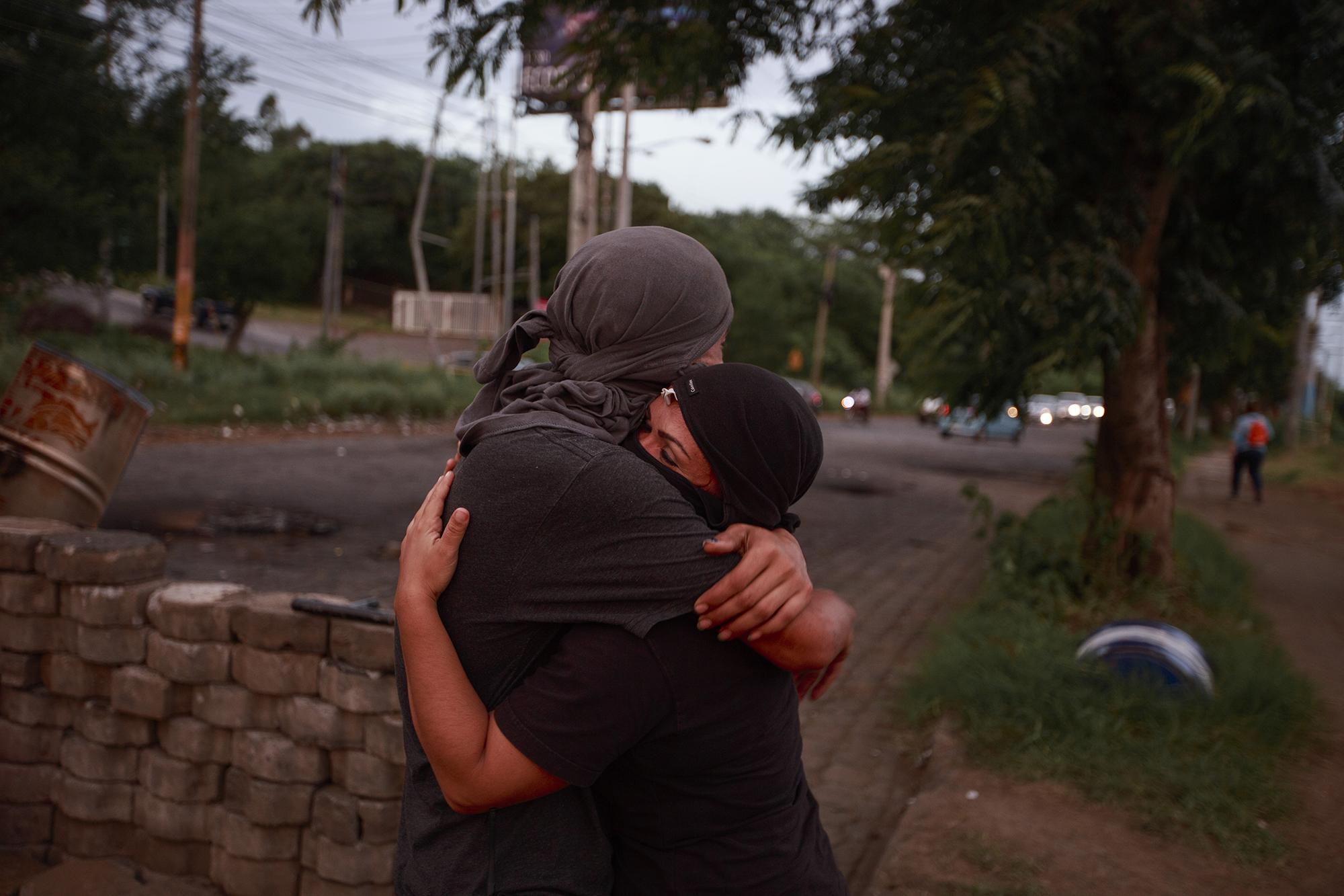 "Machete" and "Luna" embrace during their shift to stand guard at one of the barricades at the National University of Nicaragua. June 29, 2018.