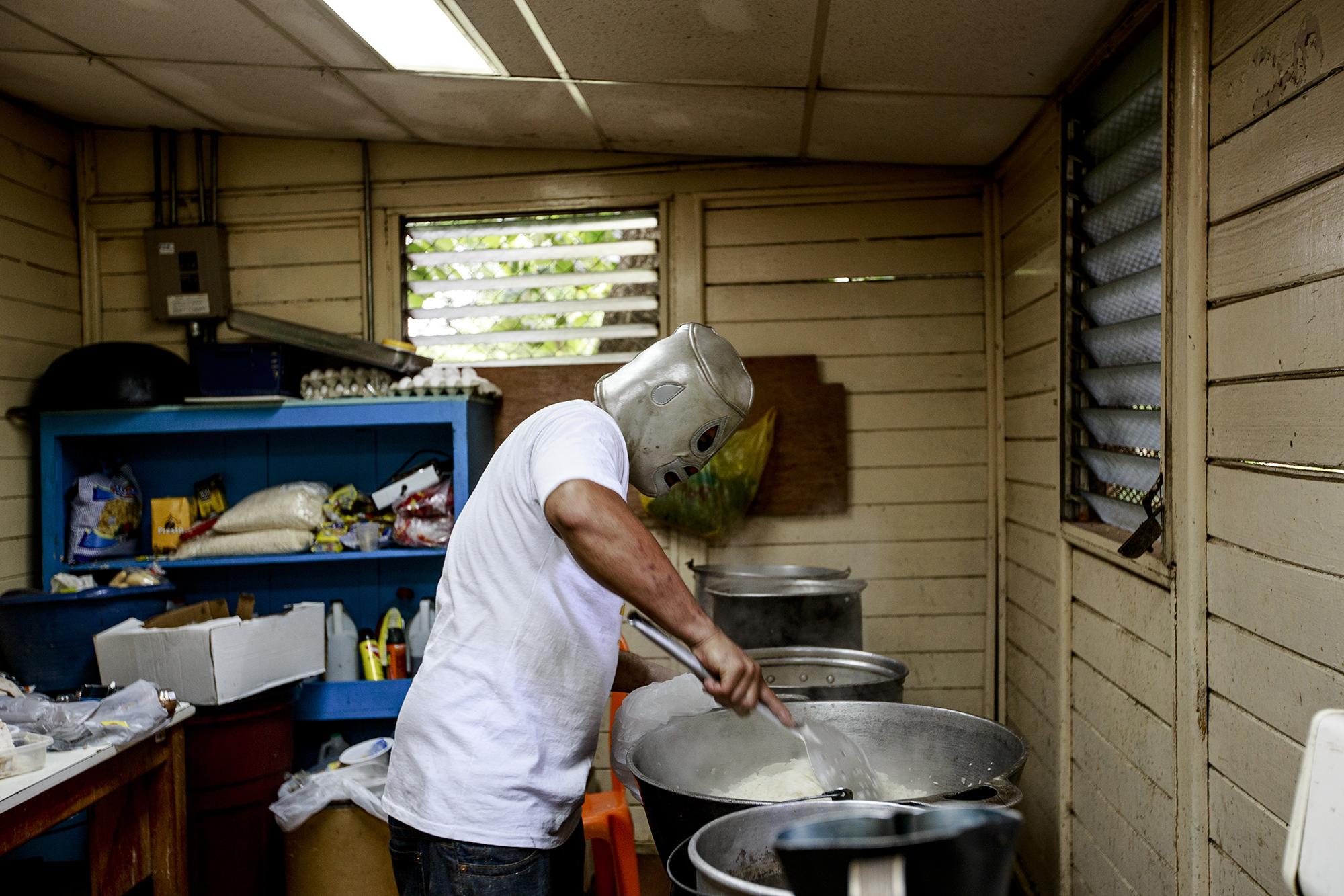 The cook in one of the wings of the UNAN protects his identity with the mask of El Santo, the legendary Mexican wrestler, as he prepares lunch for the students. The food is donated from Nicaraguans who come drop it off at the university. June 27, 2018.