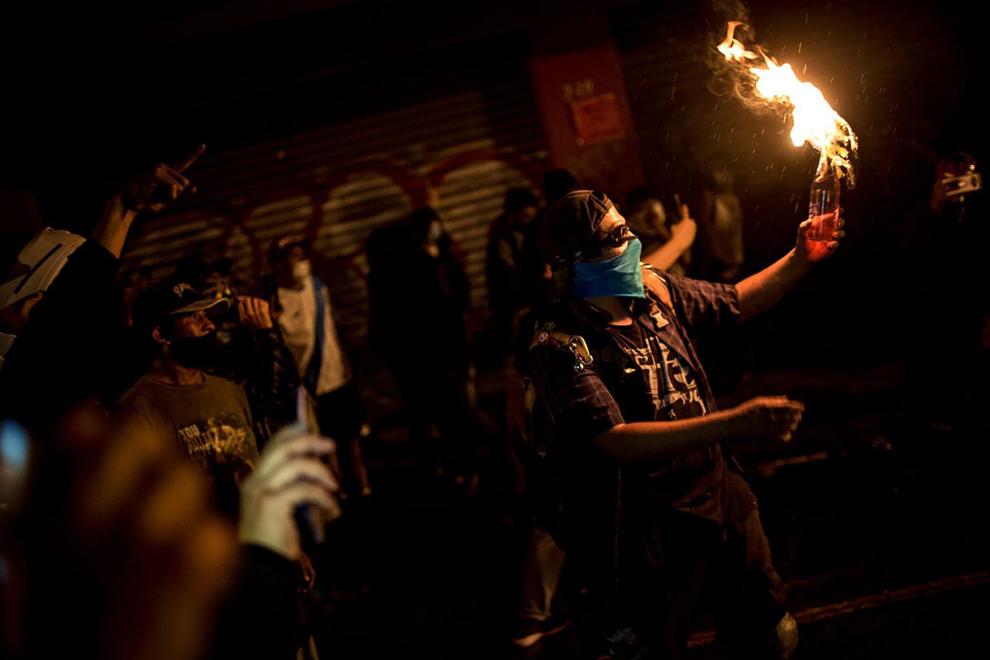 Un manifestante prende una bomba molotov durante las protestas del 21 de noviembre del 2020 en Ciudad de Guatemala. Foto: Simone Dalmasso/Plaza Pública