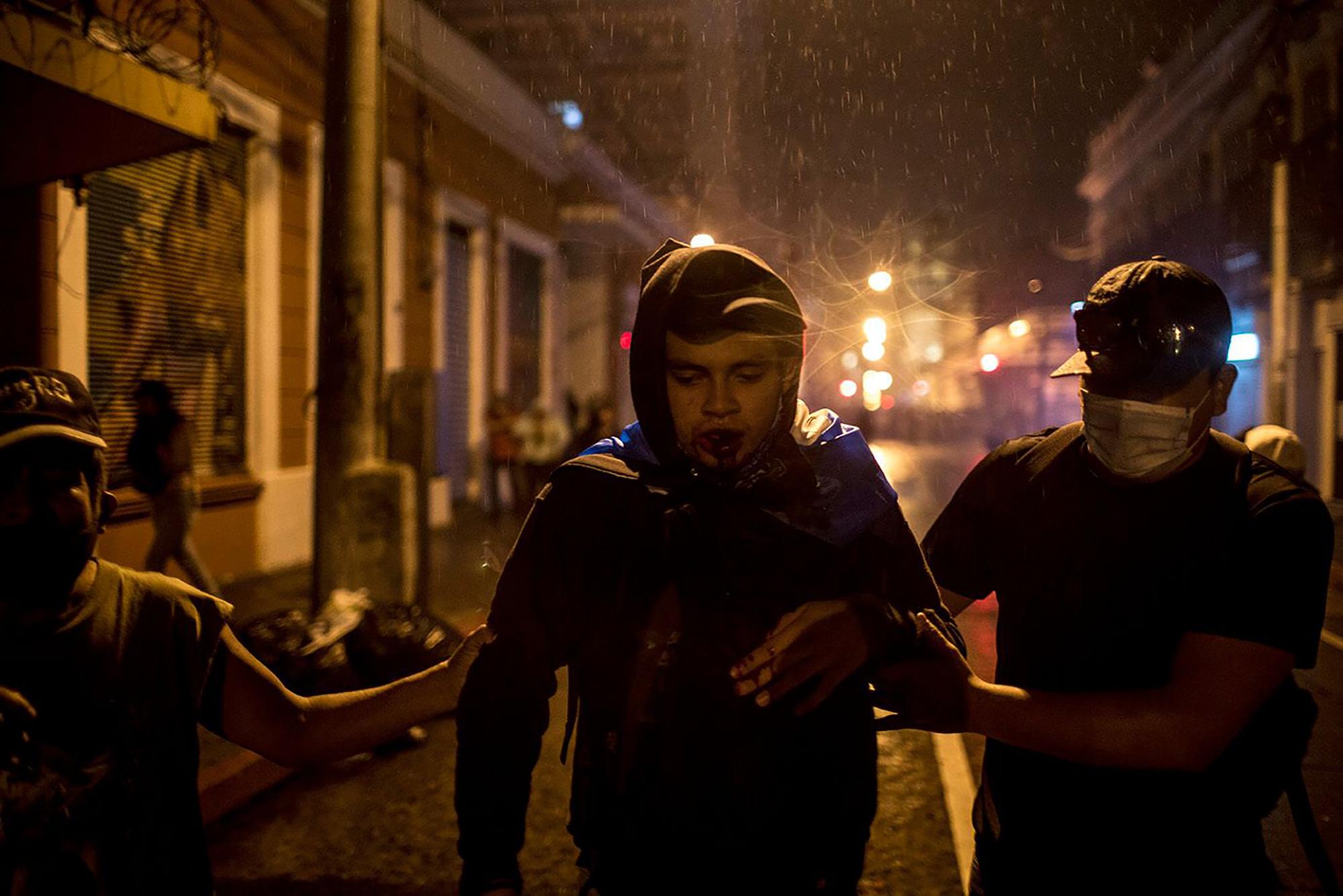 Un manifestante es auxiliado después de haber sido golpeado por un artefacto de gas lacrimógeno disparado por la Policía. Foto: Simone Dalmasso/Plaza Pública