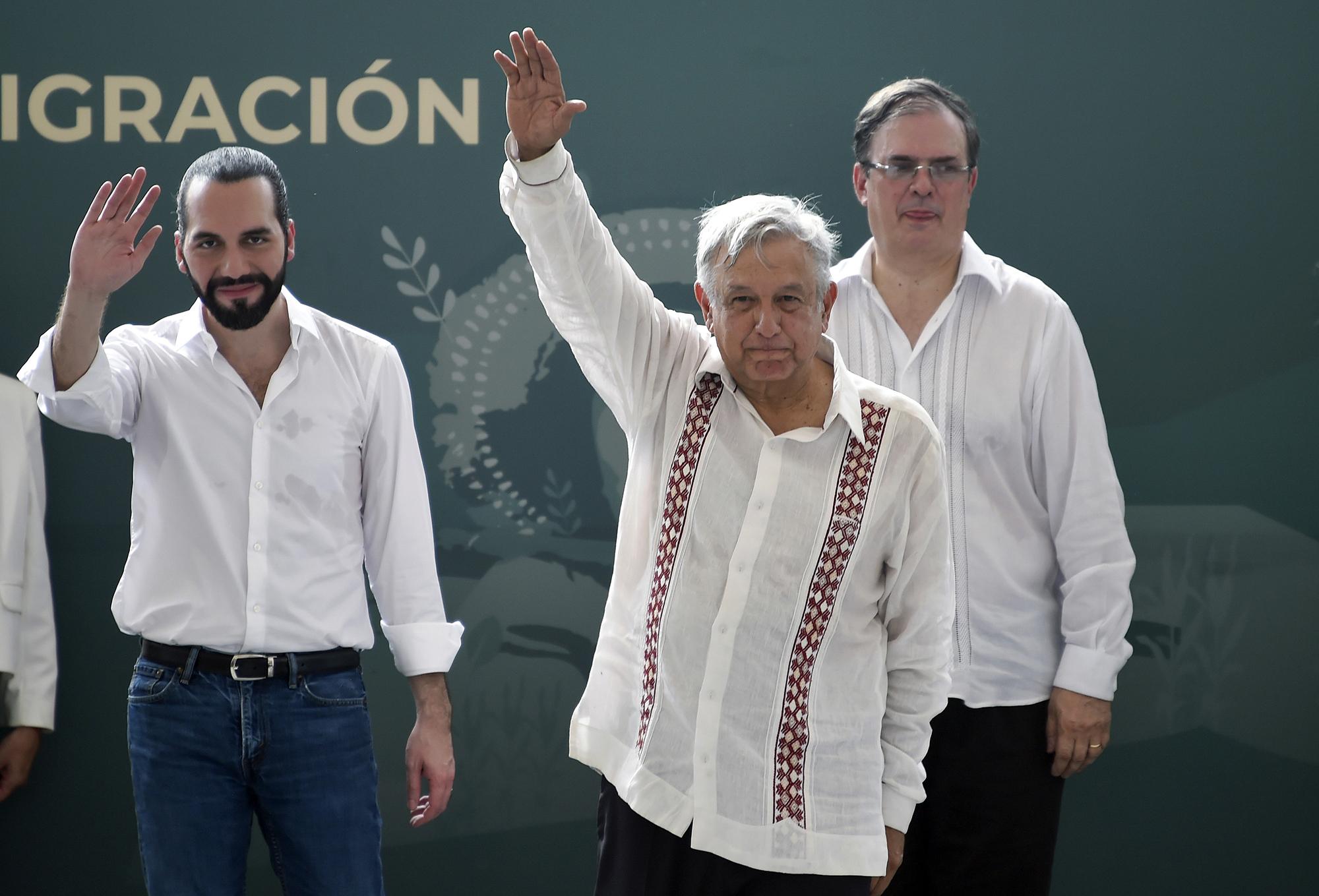 El presidente mexicano, Andrés Manuel López Obrador (C), y su homólogo de El Salvador, Nayib Bukele (L), saludan con la mano mientras el ministro de Relaciones Exteriores de México, Marcelo Ebrard, respalda durante la presentación del programa 
