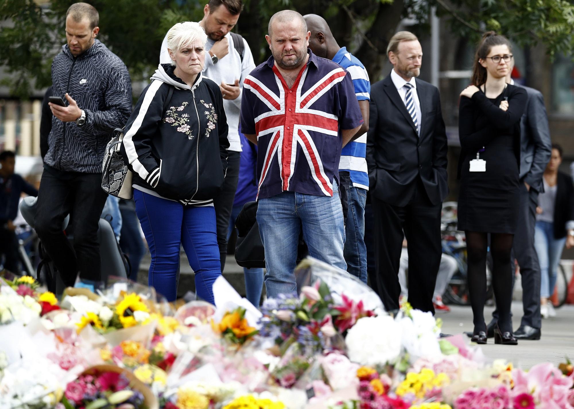 Un hombre con una camisa que tiene estampada la bandera del Reino Unido muestra sus condolencias en London Bridge, el lugar de Londres en el que el sábado 3 de junio hubo un ataque terrorista atribuido a yihadistas admiradores del Estado Islámico. Foto Odd Andersen (AFP).
