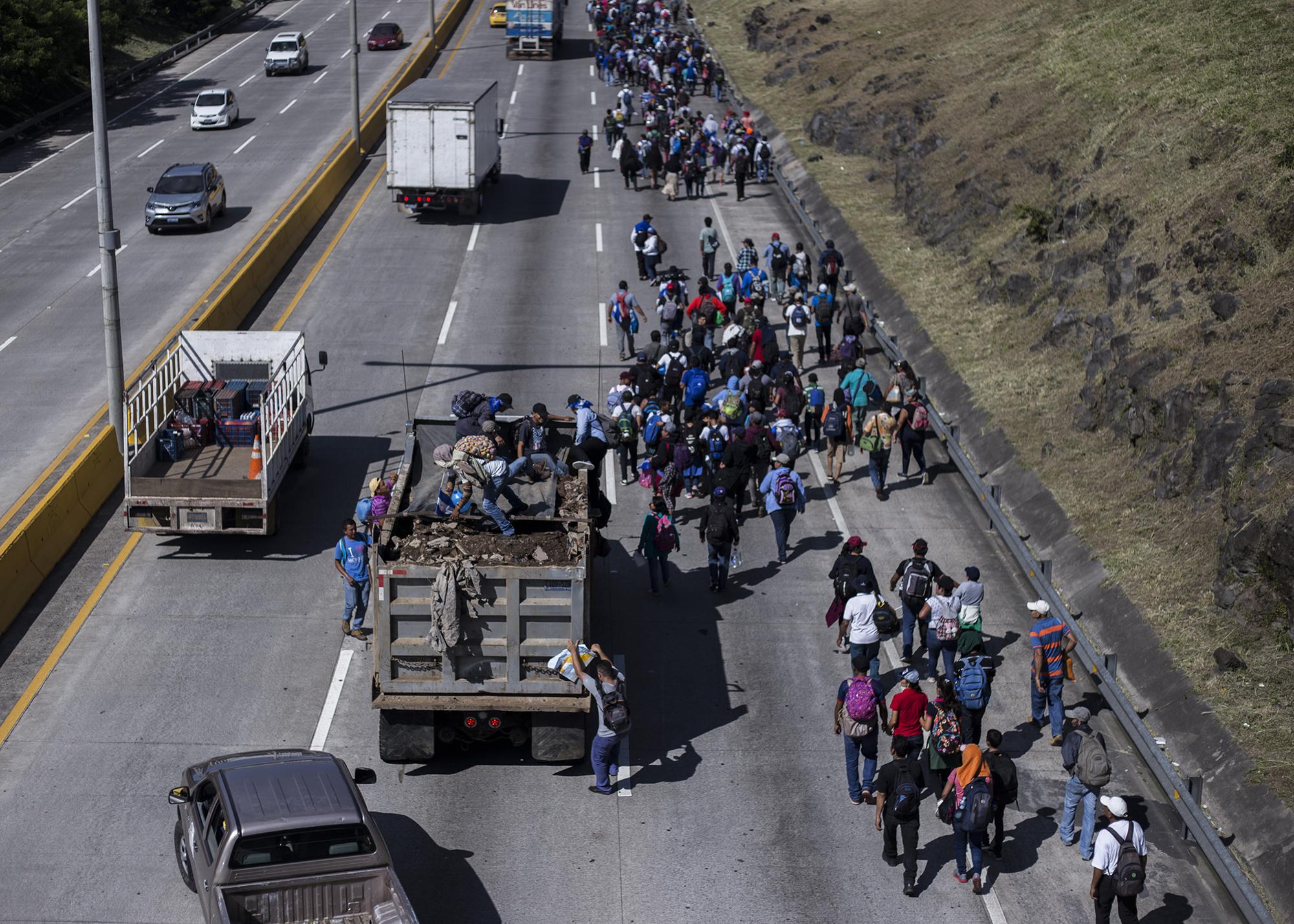 En los primeros kilómetros, los migrantes ya comenzaban a buscar opciones de transporte. En el bulevar Monseñor Romero, algunos avanzaron en un camión de volteo. Foto: Víctor Peña.