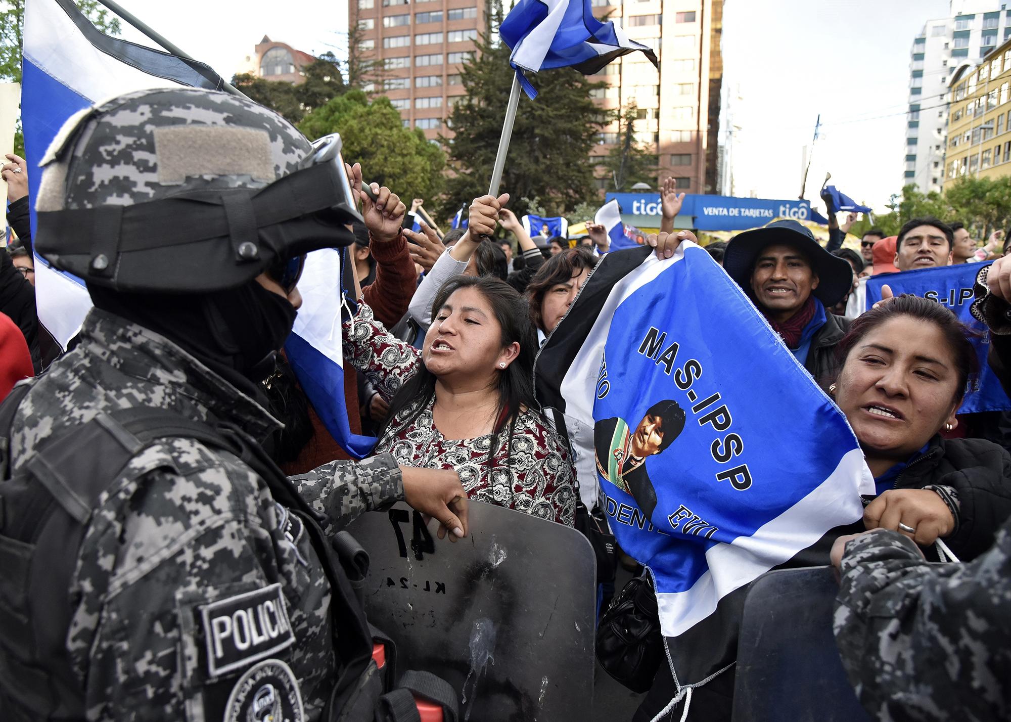 Los partidarios del presidente y candidato de Bolivia, Evo Morales, están siendo contenidos por las fuerzas de seguridad mientras gritan consignas contra los partidarios del candidato del partido 