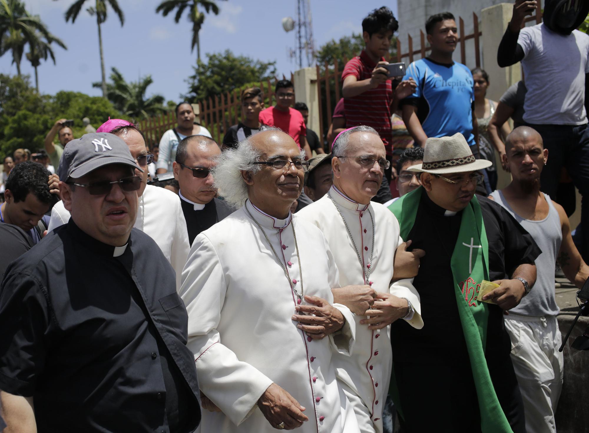 El cardenal Leopoldo Brenes (2-L) y el obispo Silvio Baez (3-L) llegan a la Basílica de San Sebastián en Diriamba, Nicaragua, el 9 de julio de 2018, donde fueron hostigados por miembros de la juventud sandinista progubernamental. / AFP PHOTO / Inti OCON