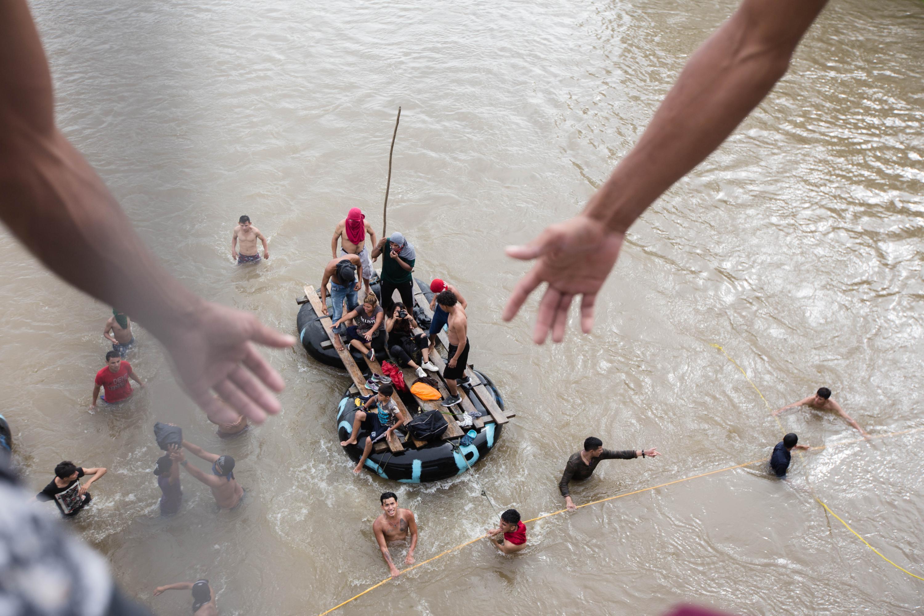 Several Mexican raftsmen approach the border bridge between Guatemala and Mexico as they encouraged migrants to jump into the Suchiate river, bringing them to Mexican shore. (El Faro/Archive)