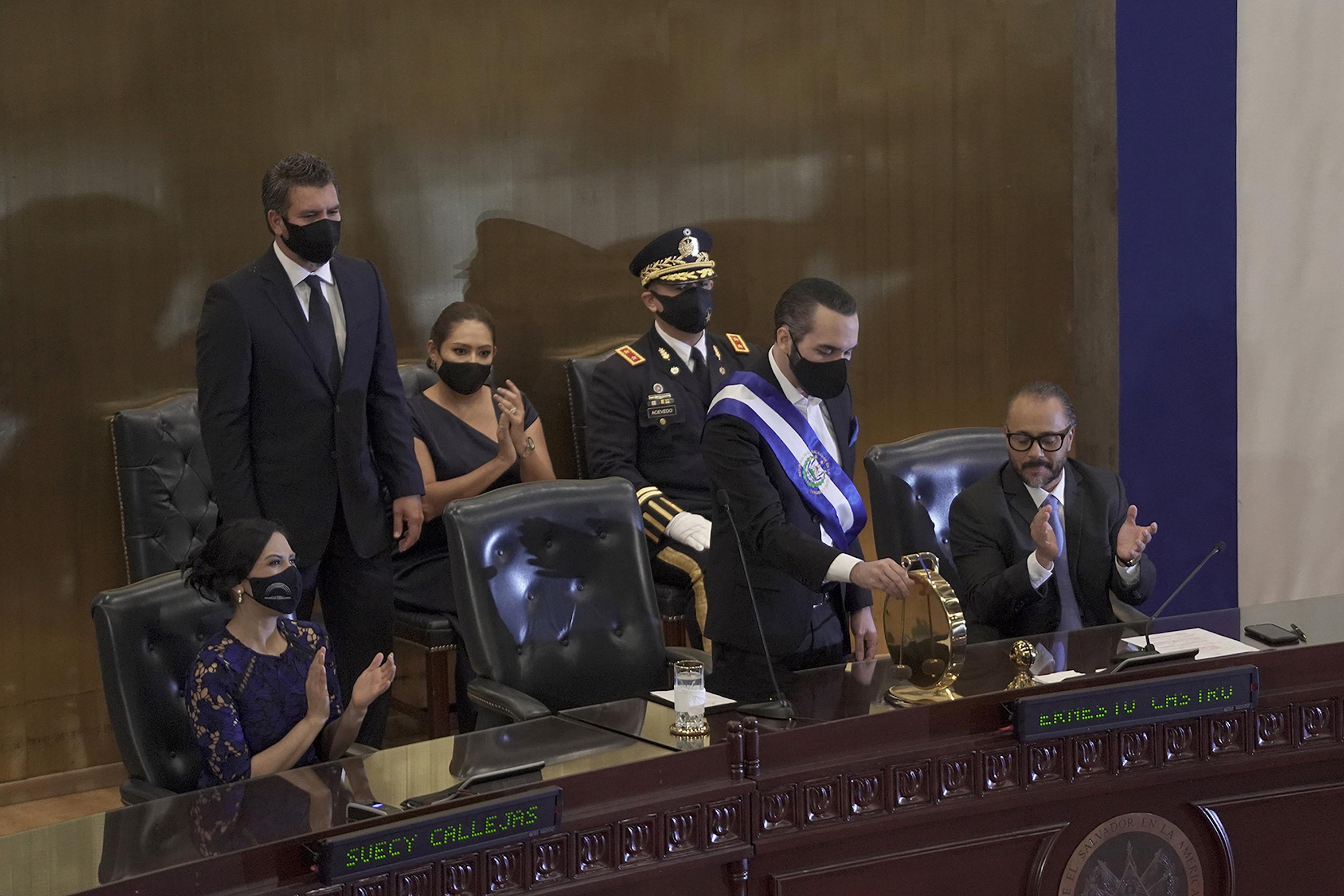Nayib Bukele strikes the gong in the Legislative Assembly chamber to open an extraordinary session to give his report on his second yearin office in June 2021. That February, his party took a supermajority in the legislature and, on its first day in office in May, illegally removed the Constitutional Chamber magistrates and the attorney general. Photo: Víctor Peñ/El Faro