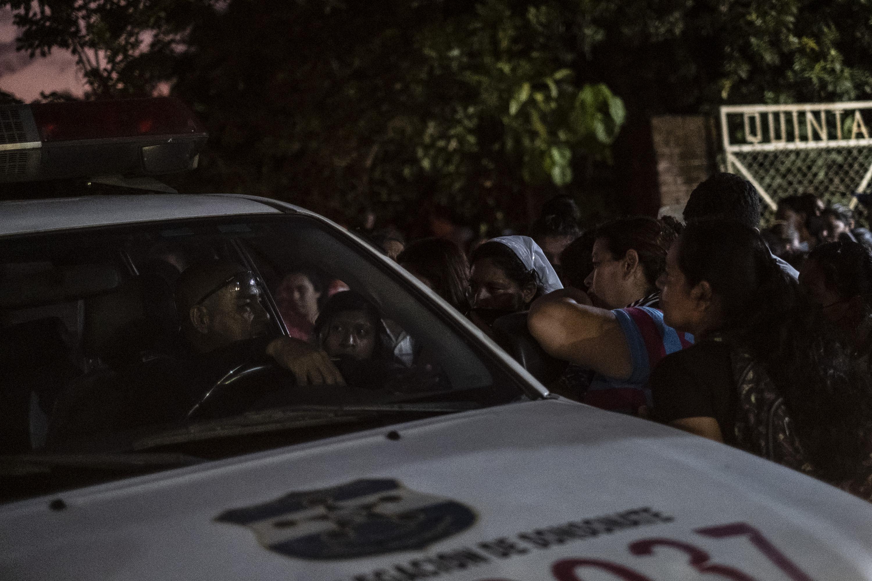 “Rumors run wild” on the street leading to Izalco Prison, says one police officer. “Despite how much you tell these women not to come, they will always find their way here,” he added as a group of women crowded around a patrol car at night on April 28 when they learned that none of their family members would be freed that day. “You try to understand their perspective, because of course a mother or a wife would do it for a man, but we can’t do anything to help them here.” Photo: Carlos Barrera/El Faro