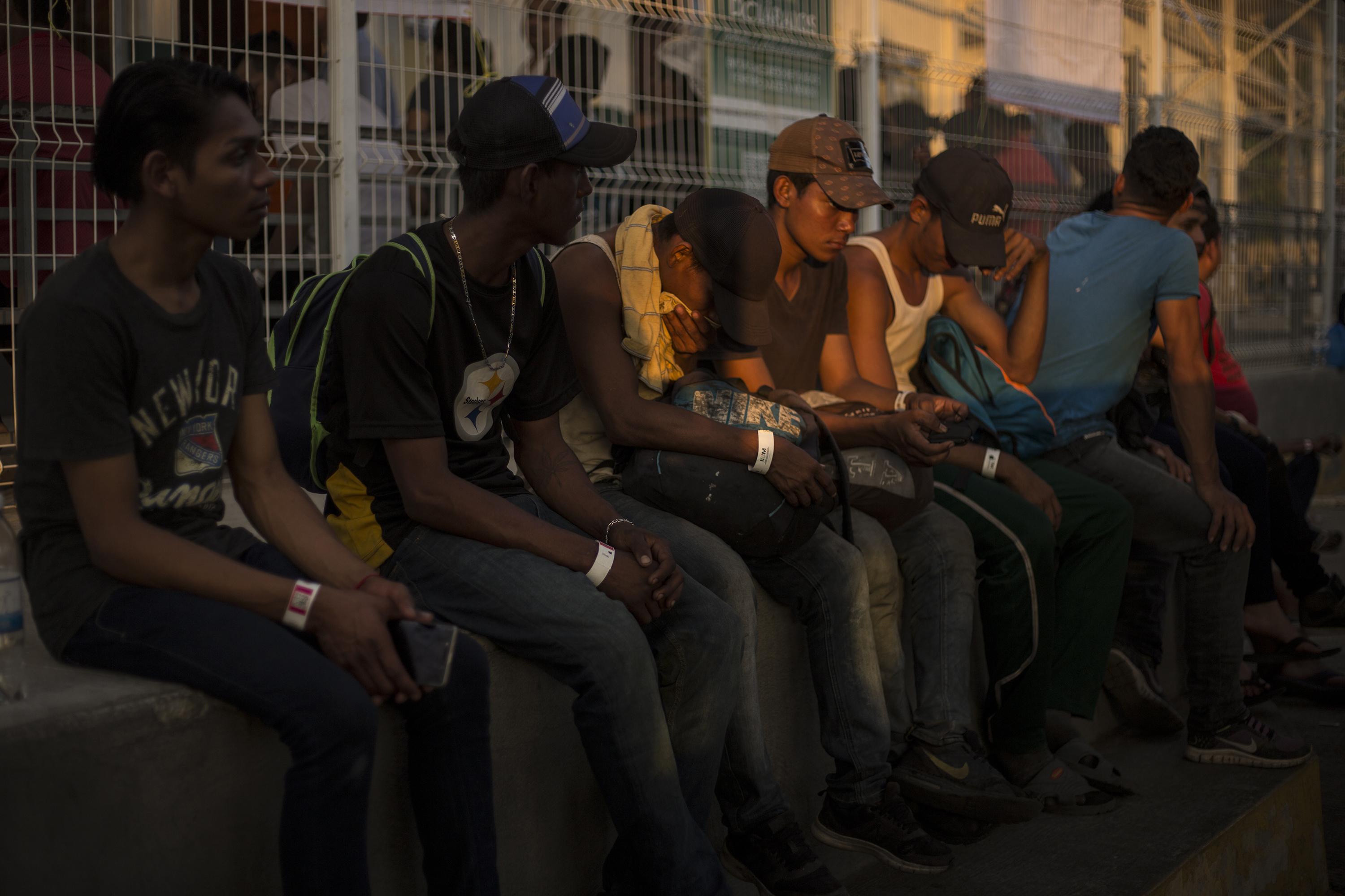 Migrantes salvadoreños esperan sobre el puebrte Rodolfo Robles, que une Guatemala y México, el 17 de enero de 2019. México prometió carnet de residencia para migrantes que huyen de los países de Centroamérica. Foto de El Faro: Víctor Peña. 