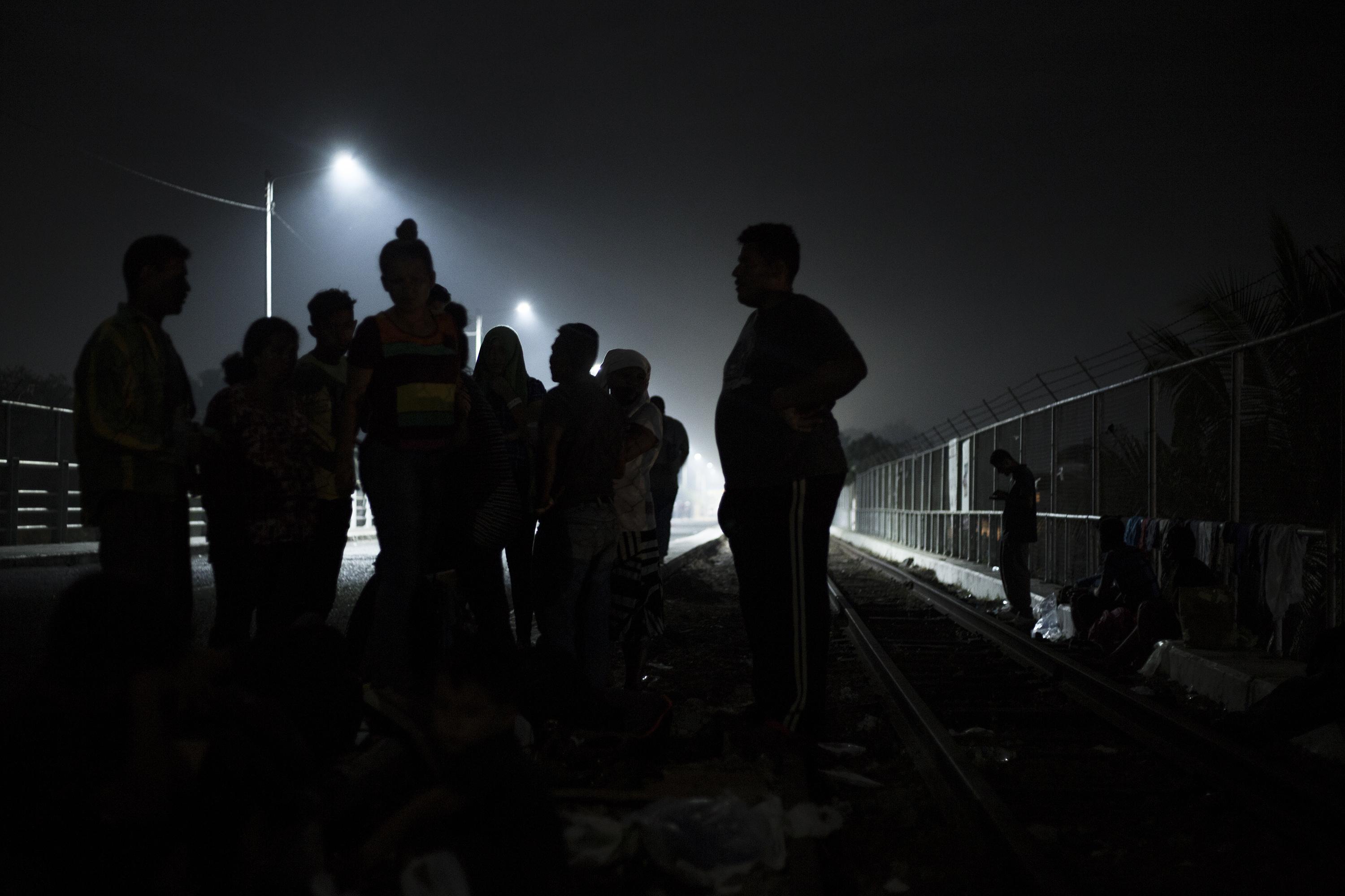 Migrantes centroamericanos se alistan para dormir sobre las líneas del tren sobre el puente Rodolfo Robles, que une Guatemala y México, en Tecún Umán, el 17 de enero de 2019. Foto de El Faro: Víctor Peña. 